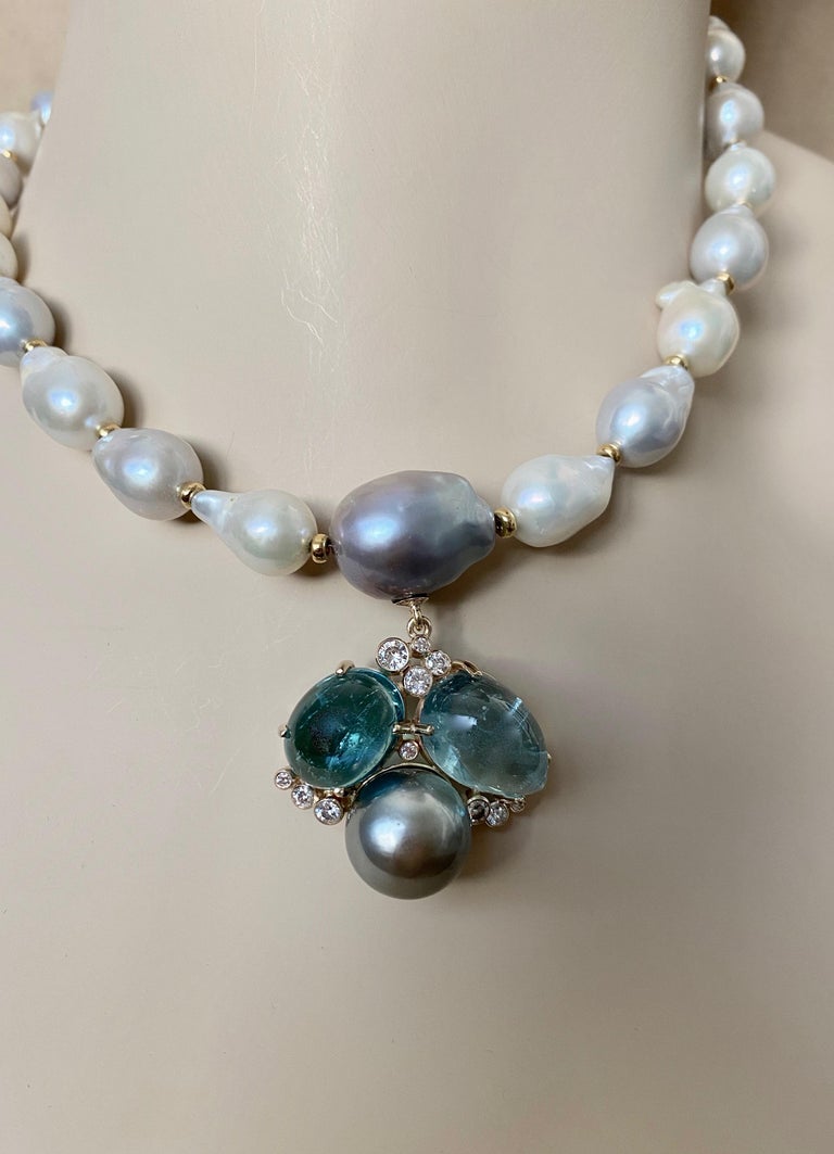Indicolite tourmaline (origin: Brazil) is integrated with aquamarine and Tahitian pearl in this unique Confetti necklace.  The cabochons are delicately colored, well cut and polished with inclusions typically found in cabochon gems.  The medium gray