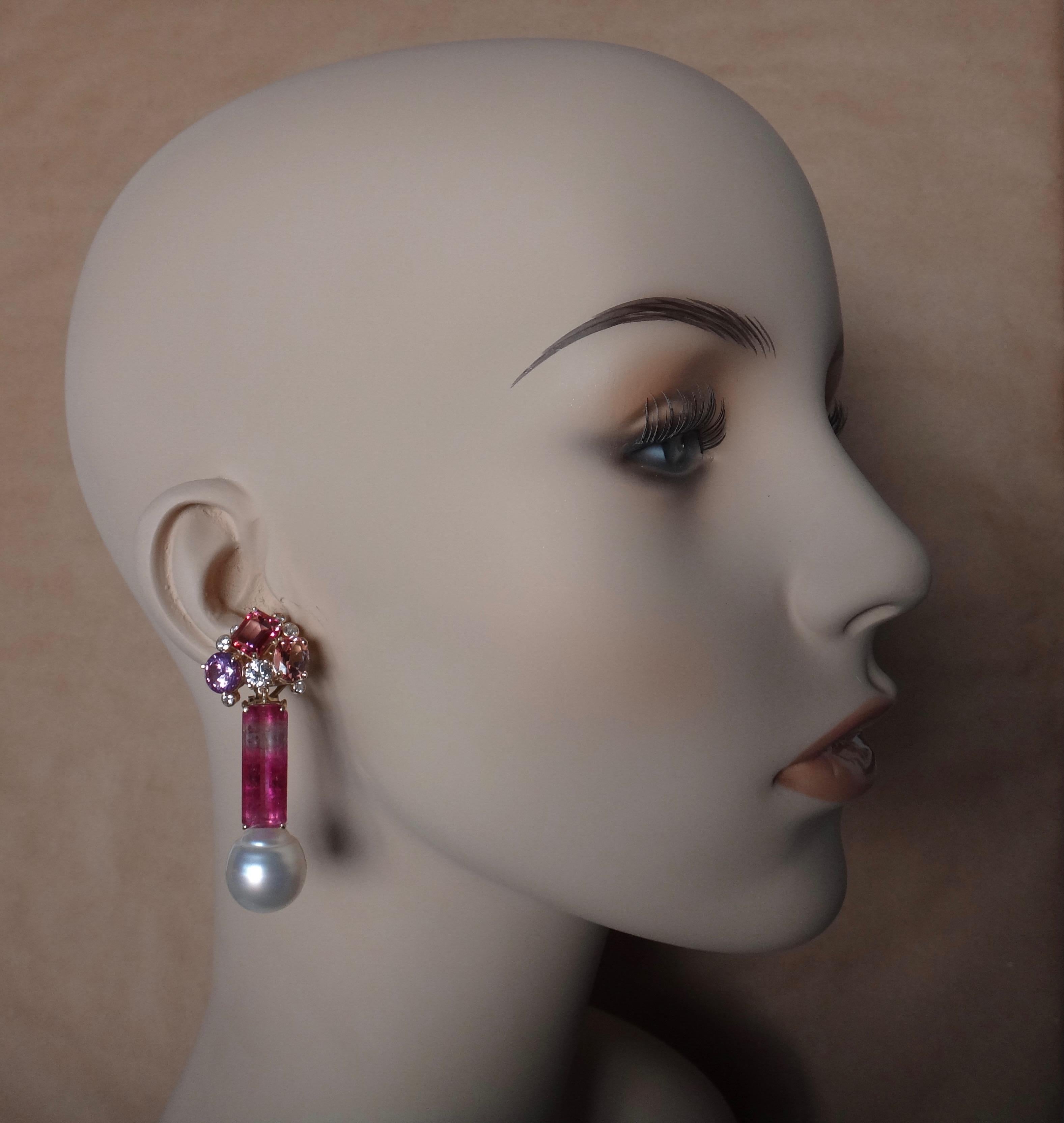 A pair of wonderfully matched pink, bi-color tourmalines (origin: Brazil) are featured in these one-of-a-kind dangle earrings.  The confetti tops from which the emerald cut gemstones drop are composed of three pink topaz of various shapes and color