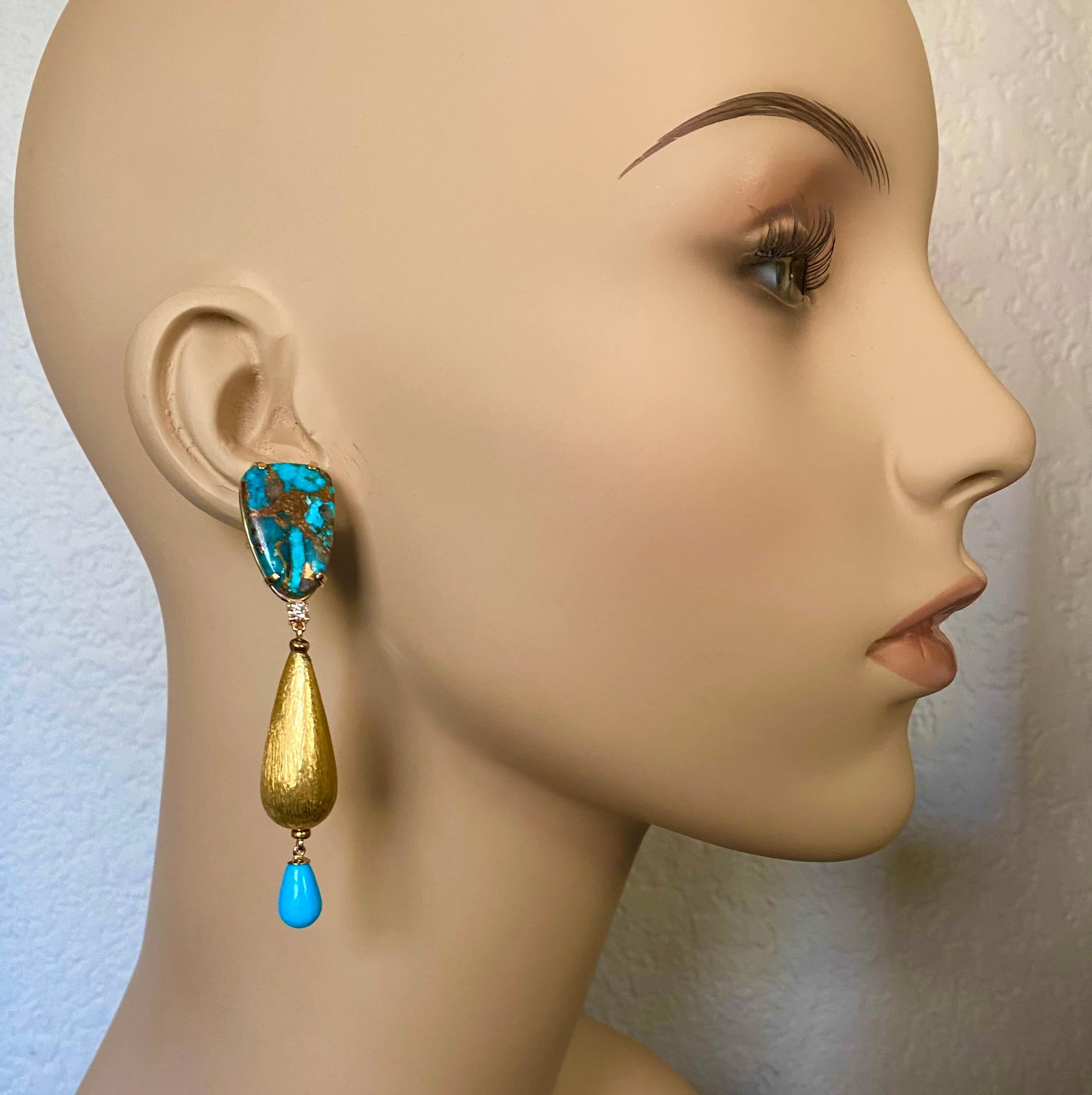 Turquoise is highlighted in these dramatic dangle earrings.  The cabochons are copper bearing turquoise found in Arizona.  The are well matched, cut and polished to a lustrous finish.  Dangling from below are Sleeping Beauty turquoise drops, also