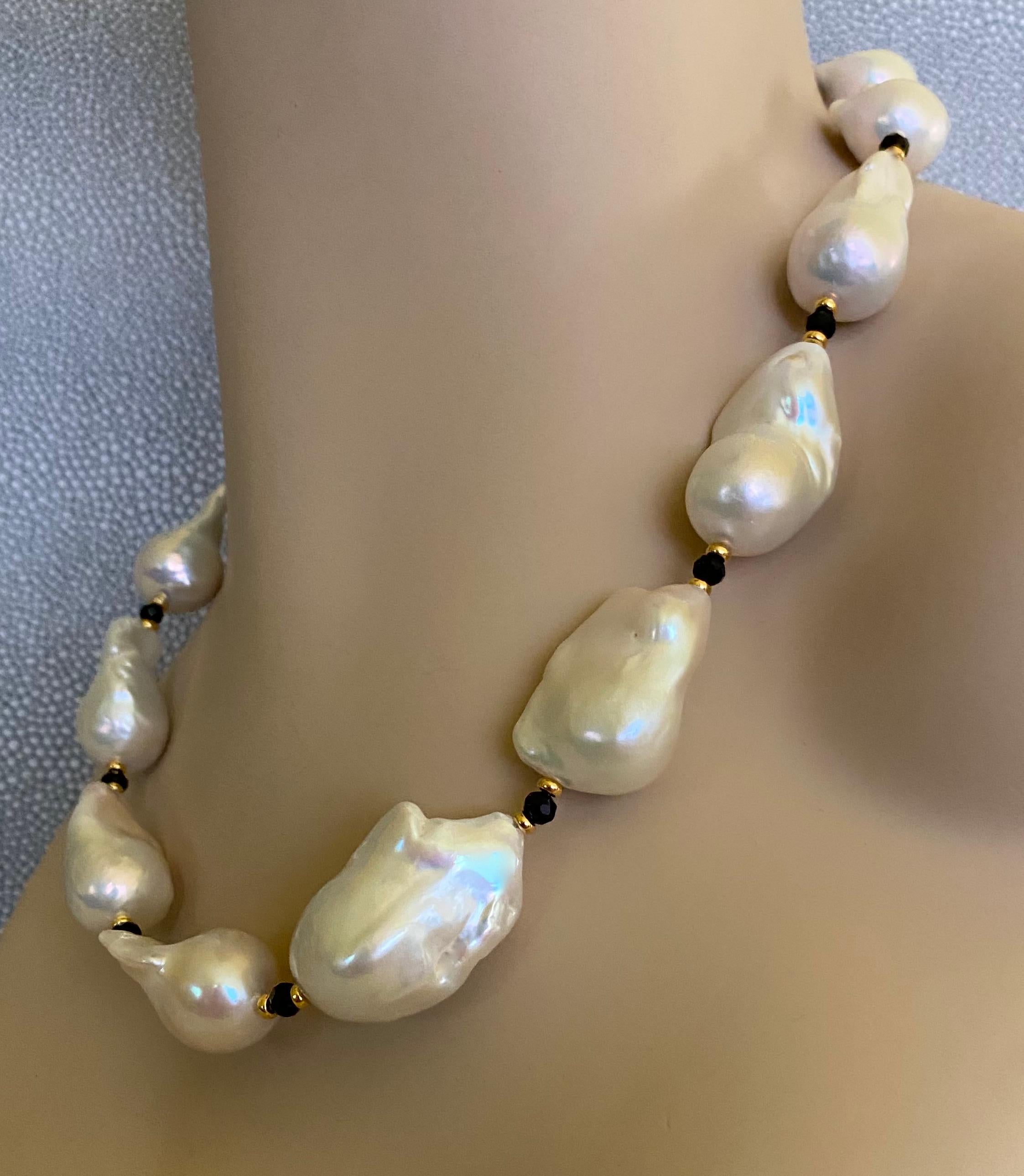 White baroque pearls are featured in this bold necklace.  The pearls are ginormous, the largest measures fully 1.38 inches in length.  The nacre possess great luster with no blemishes.  The pearls are spaced with small faceted black spinel and gold