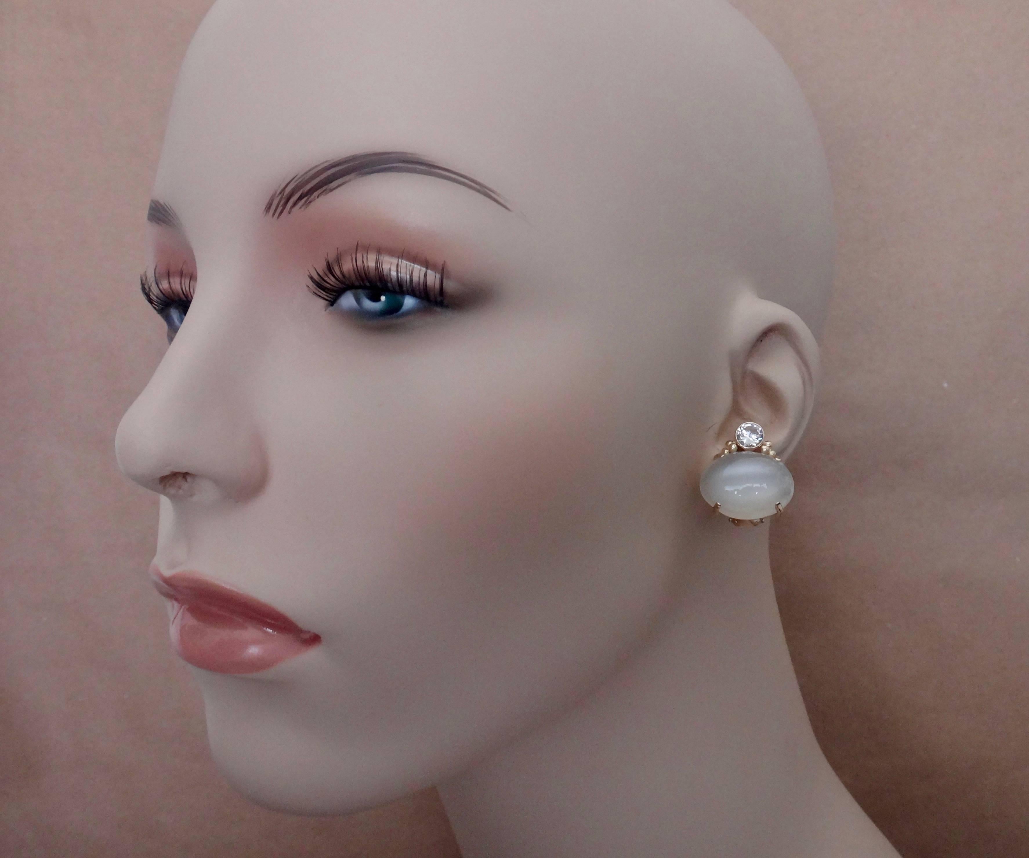 A perfectly matched pair of luminous, white moonstones are paired with brilliant cut silver sapphires in these classic, summery button earrings.  The moonstones are prong set while the sapphires are bezel set and detailed with small gold beads.  The