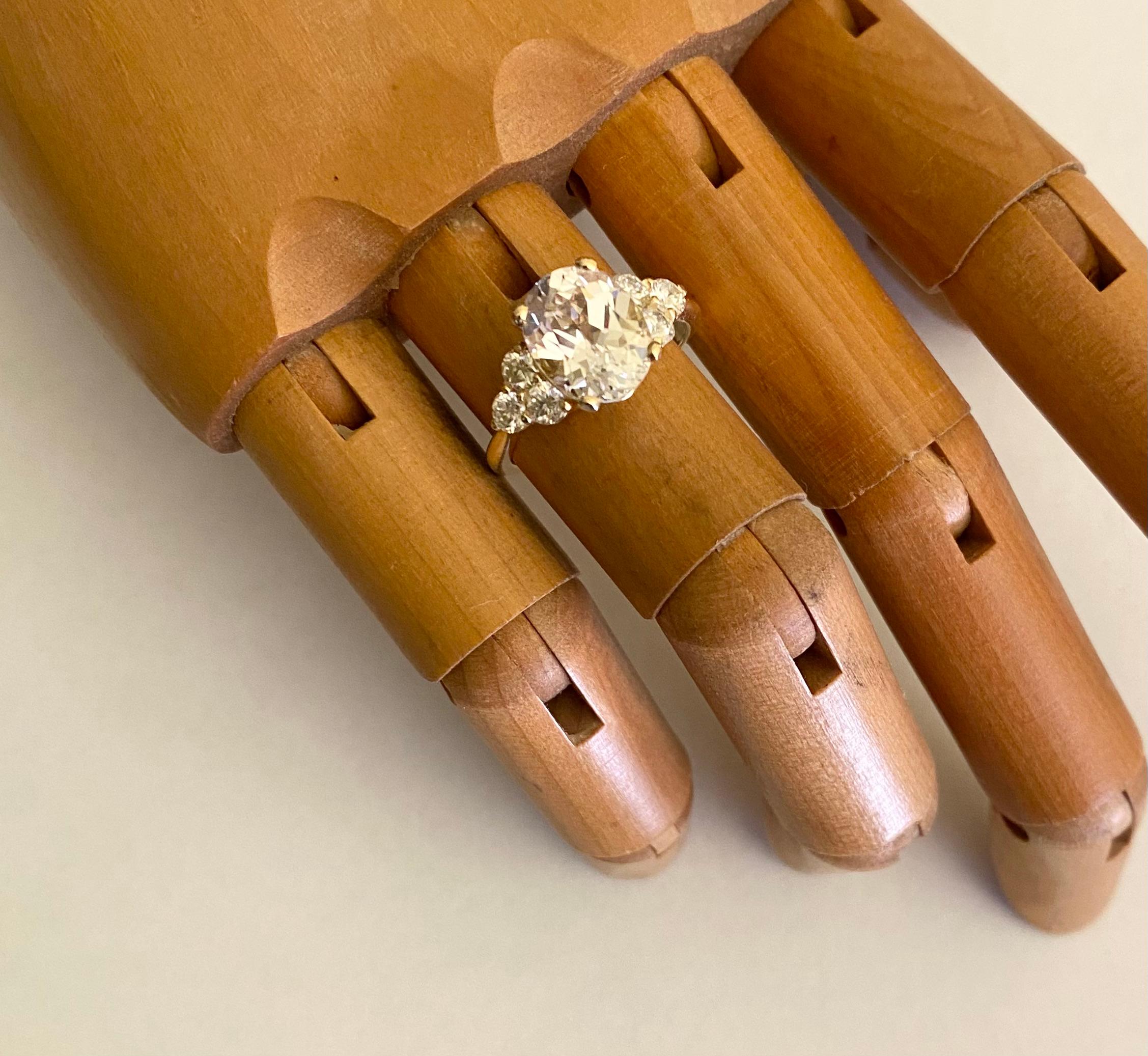 Lo zaffiro bianco è completato da moissaniti bianche in questo classico e versatile anello a grappolo.  Lo zaffiro (origine: Thailandia) è di forma ovale, completamente incolore e sapientemente sfaccettato.  La gemma è affiancata da gruppi di tre