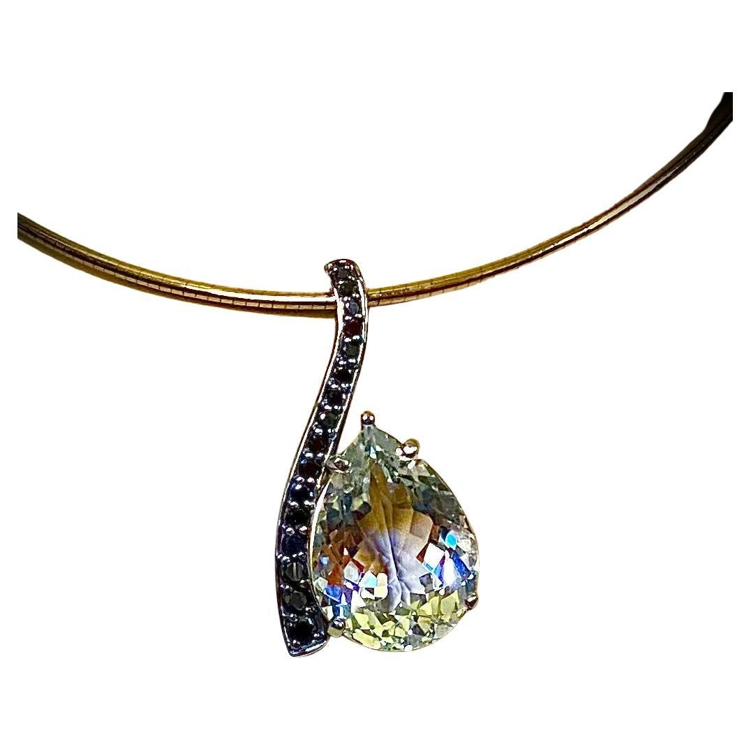 Questo ciondolo ondulato è caratterizzato da uno splendido topazio bianco.  Il topazio (origine: Brasile) ha una forma a pera ben tagliata e lucidata ed è completamente incolore.  I diamanti neri sono incastonati in una montatura ondulata in oro