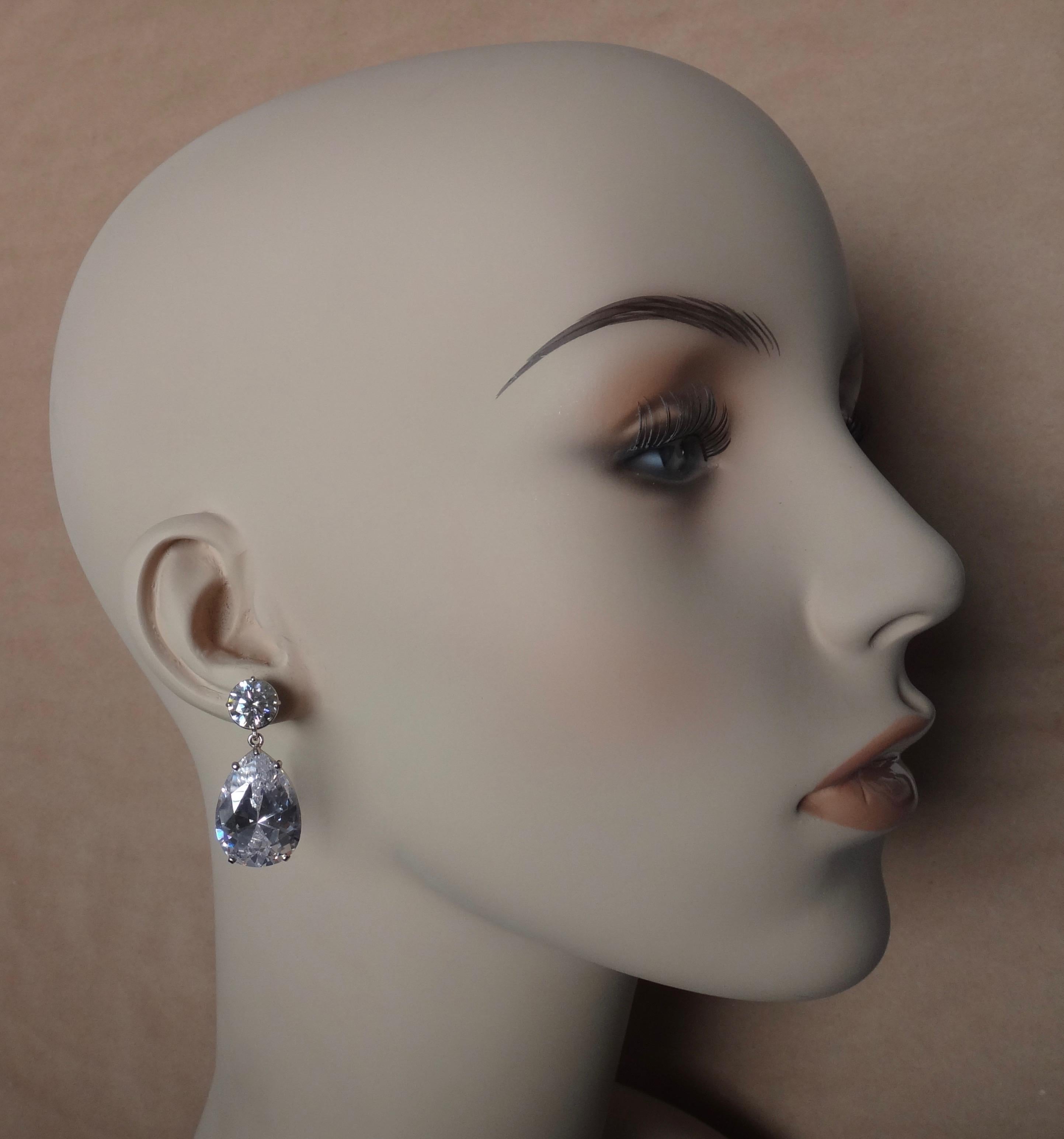 Brilliant cut white sapphire (or is sometimes referred to as silver sapphire, origin: Thailand) is paired with large pear shaped platinum topaz in these classic and glamorous dangle earrings.  All four gems are colorless, eye clean, well faceted,