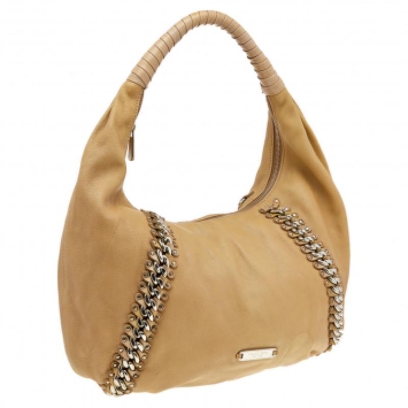 Des sacs à main aussi jolis que celui de Michael Kors ne sont pas des créations que l'on trouve tous les jours. C'est pourquoi ce sac mérite une place dans votre placard. Il a été confectionné en cuir beige et est agrémenté de chaînes. Le hobo