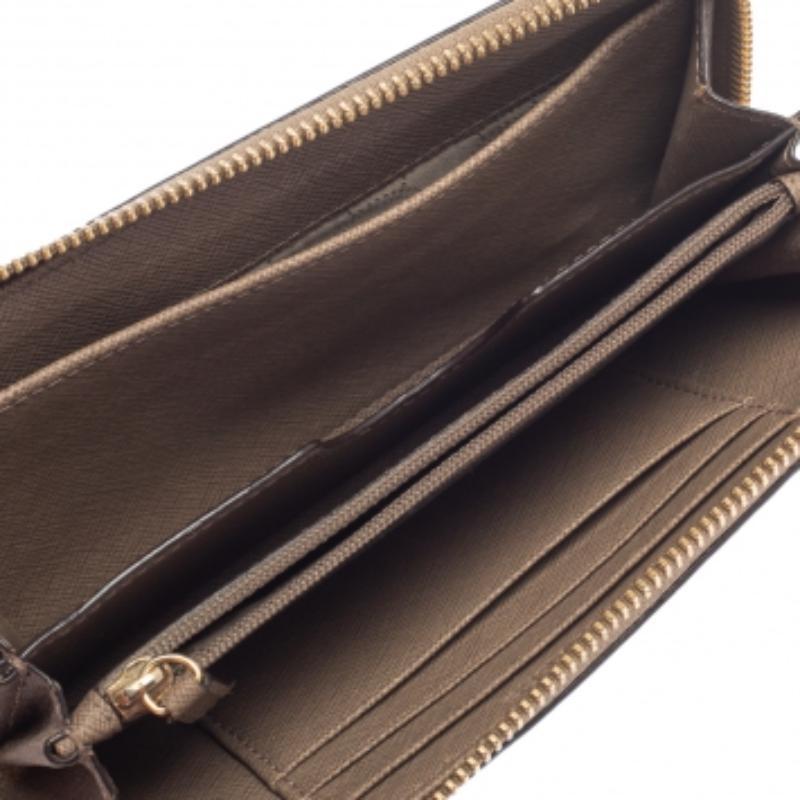 Accessorizing gets a new avatar with this gorgeous wallet from Michael Kors. Effortlessly carry your monetary essentials with this creation made from brown leather. The zip-around closure secures the compartmentalized interior effortlessly.