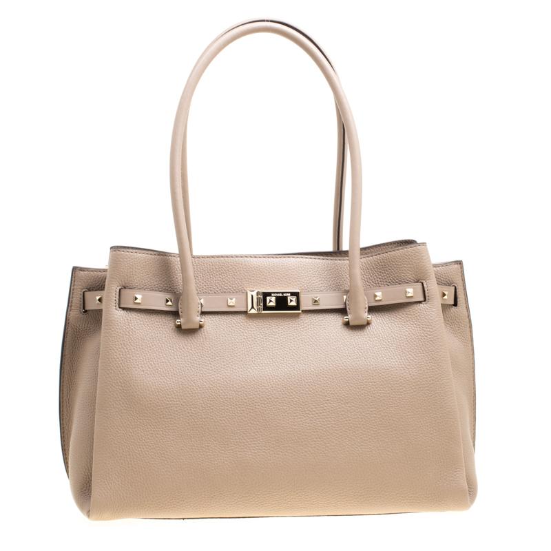 Diese Addison-Tasche aus beigefarbenem:: genarbtem Leder ist perfekt für den Alltag. Die Tasche ist mit zwei gerollten Henkeln und dem charakteristischen Markenschriftzug auf der Oberseite ausgestattet. Die Tasche ist mit einem Nietenbesatz an der