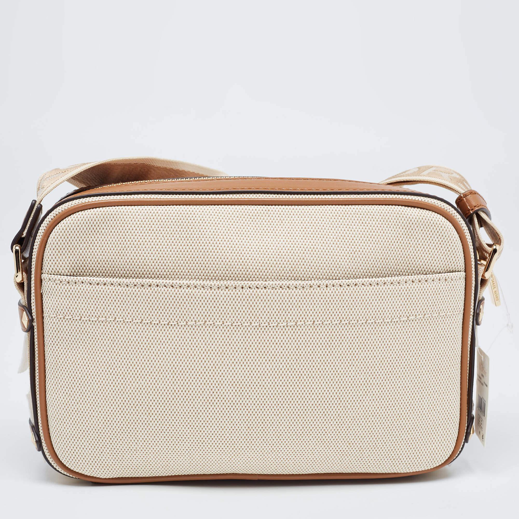 This Michael Kors bag is beautiful in so many ways. From its design to its structure, this bag exudes charm and high-end fashion. The bag flaunts the beige-tan signature coated canvas on the exterior with the gold-toned logo plaque and contrast
