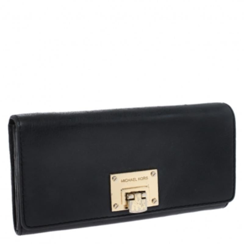  Porta con te i tuoi oggetti quotidiani e crea un look elegante con questo portafoglio di Michael Kors. Il robusto portafoglio è realizzato in pelle nera e conferisce un fascino sofisticato al tuo look. Ha una patta frontale con chiusura dorata ed è