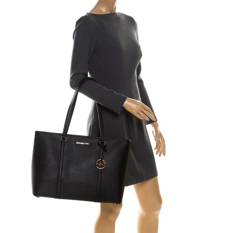 Fabulous and stylish like no other, this Michael Kors Sady tote is here to charm one an all! The black bag is crafted from leather and features dual top handles with an attached MK charm. The zip-top closure opens to a spacious satin-lined interior