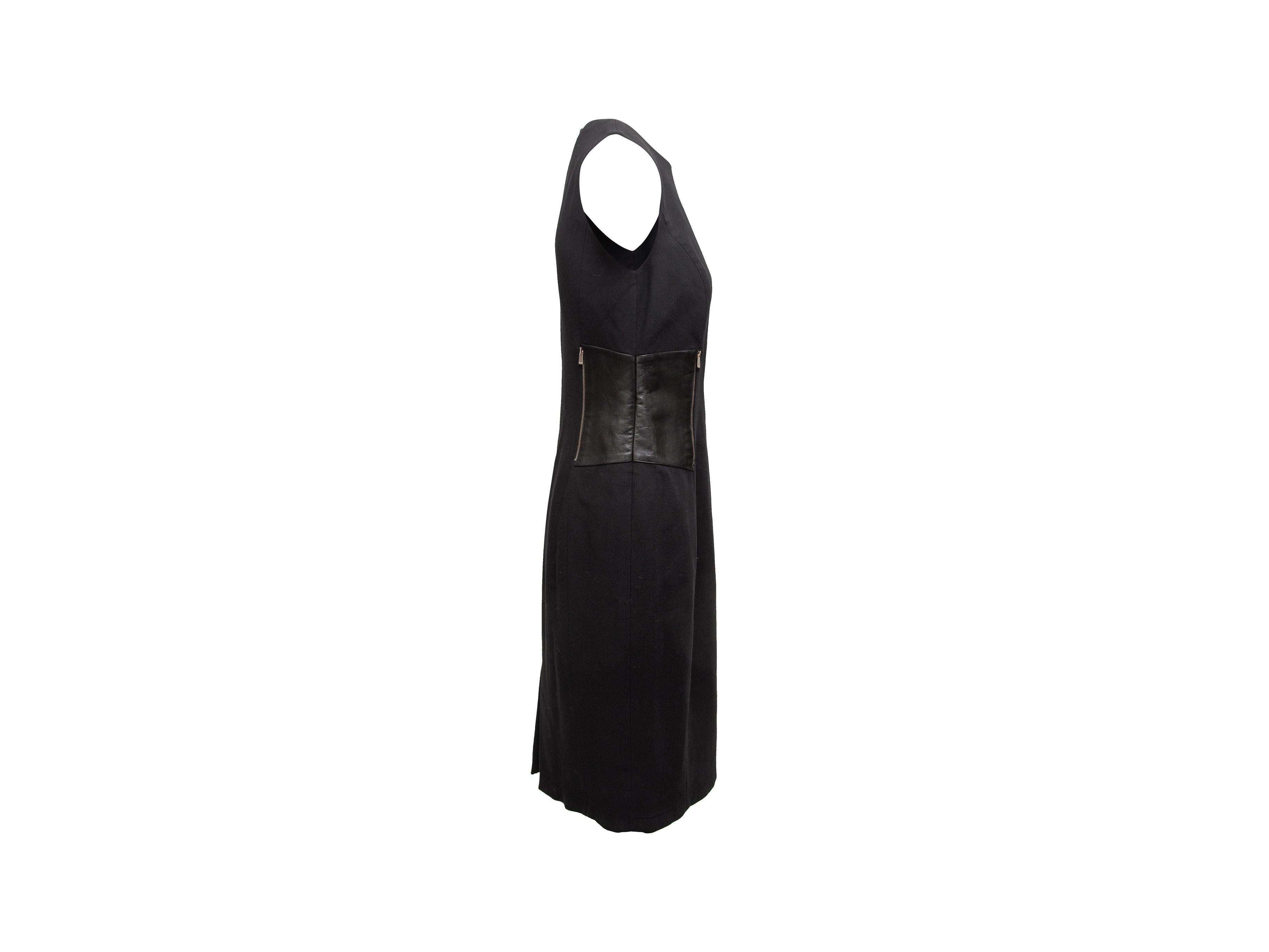 Product details: Black virgin wool sleeveless midi dress by Michael Kors. Crew neck. Leather panels at sides featuring zip accents. Zip closure at center back. 28