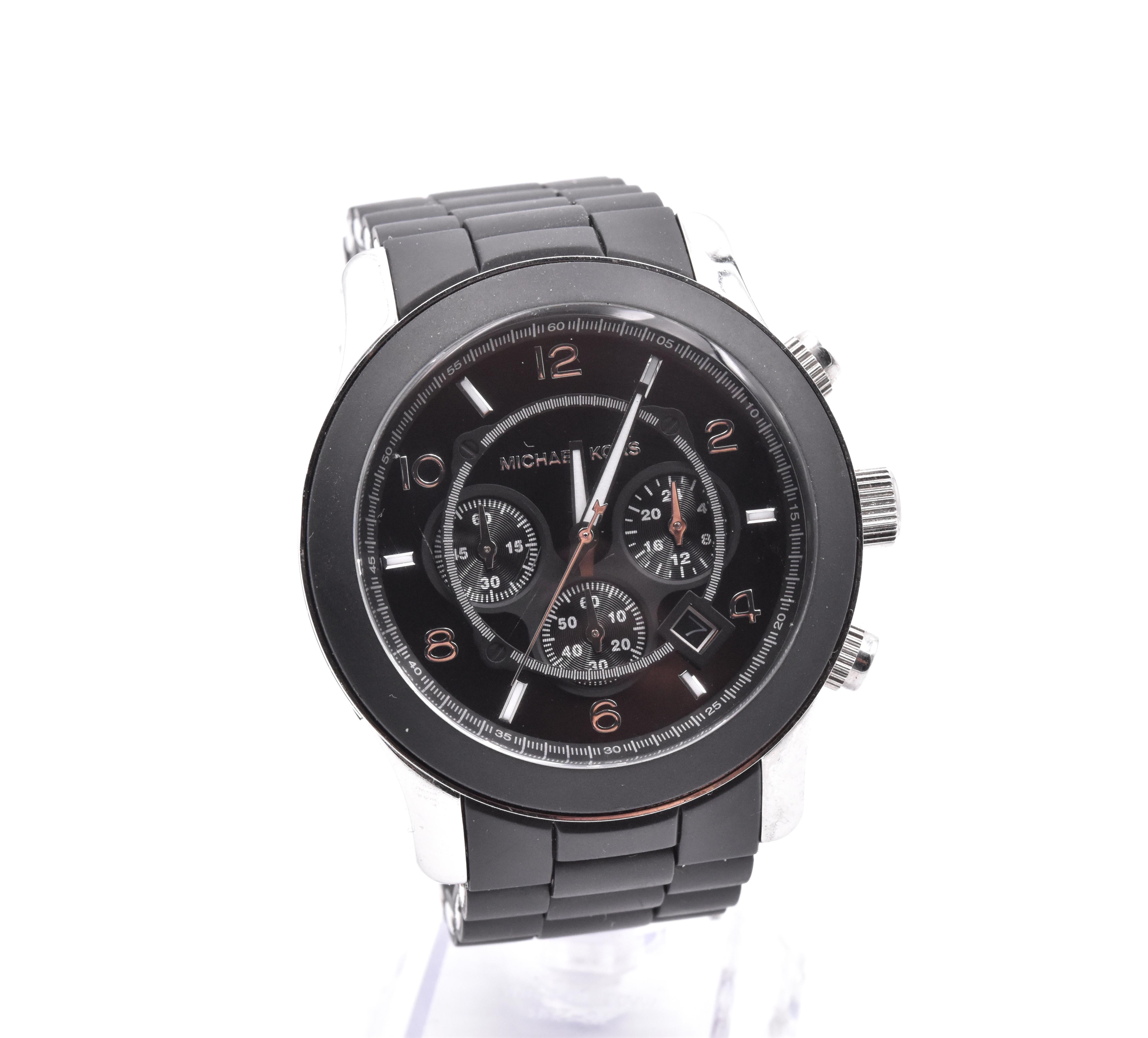 Movement: quartz
Function: Date, hours, minutes, seconds, chronograph
Case: 44mm round case, sapphire crystal, pull crown, crystal bezel 
Band: black rubber, stainless steel deployment clastp
Dial: Black alternating stick and Arabic numeral dial 