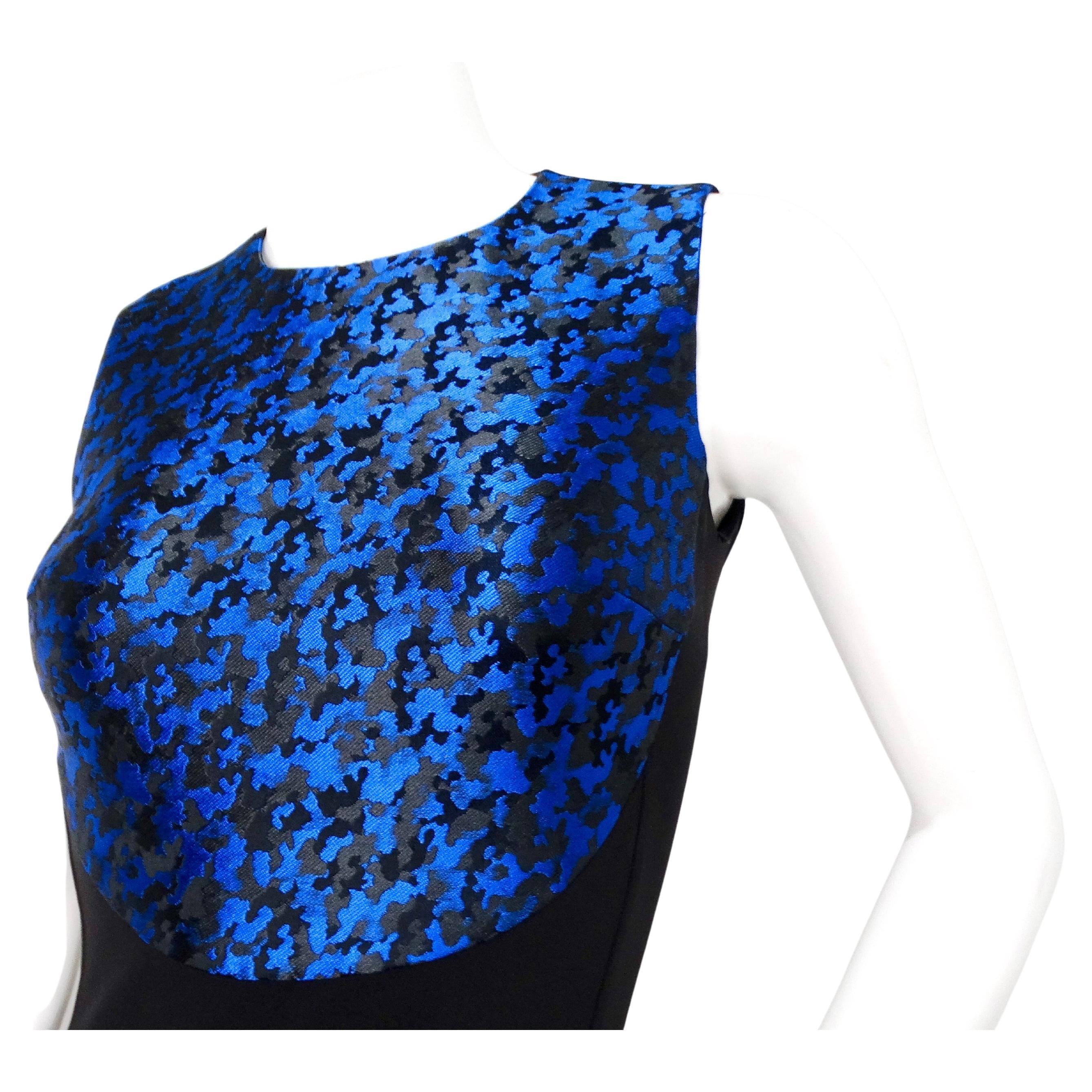 Il Michael Kors Blue & Black Camouflage Print Midi Dress è un pezzo sorprendente e sofisticato che unisce perfettamente lo stile contemporaneo con un tocco di grinta. Questo abito, che offre comfort e struttura, presenta un'audace fantasia mimetica