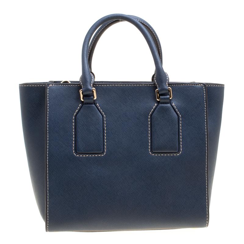 Michael Kors brings you this handy bag that will dutifully support you wherever you go. It has been crafted from leather in blue and equipped with a zipper that secures a spacious fabric interior capable of holding all your necessities. Lastly, it