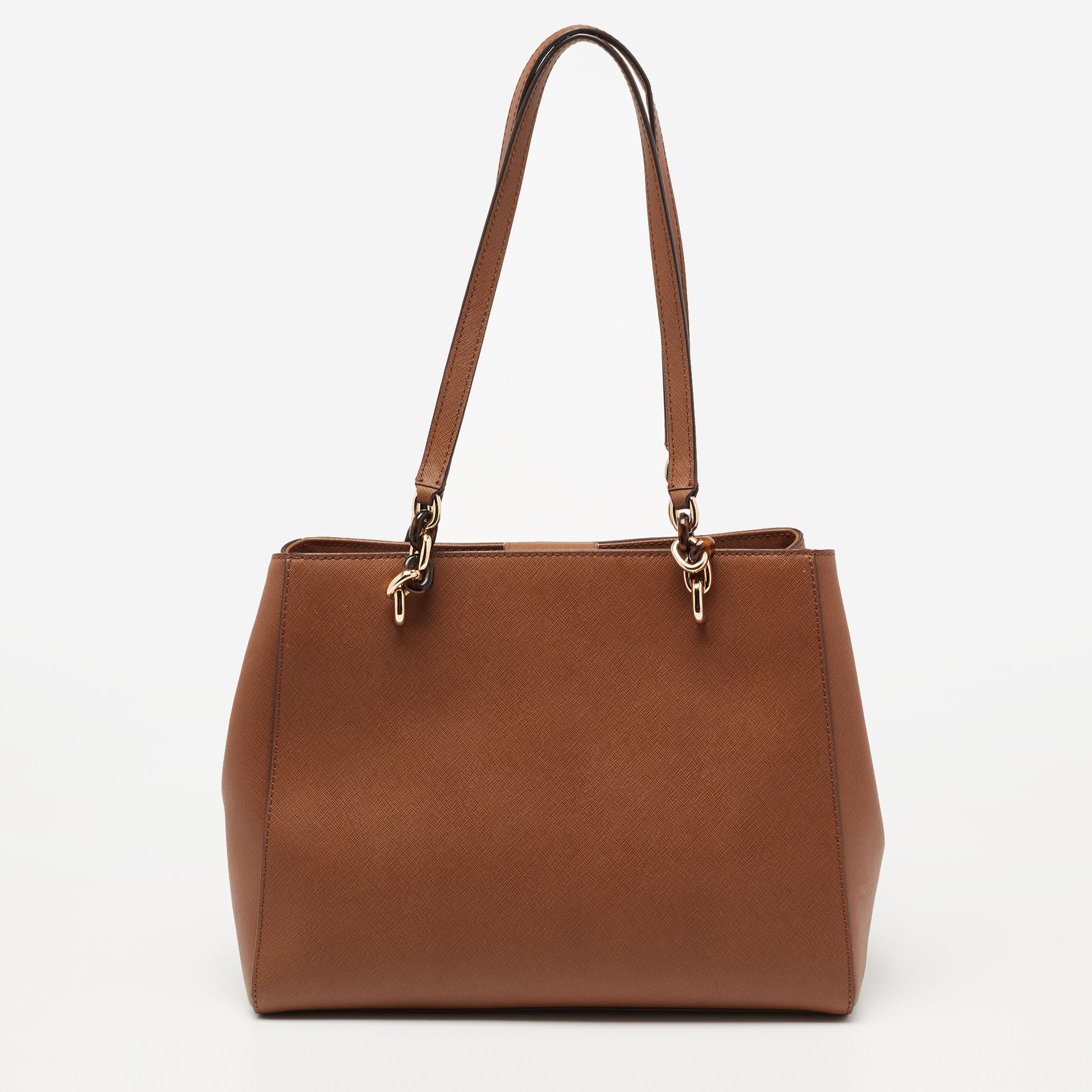 This Michael Kors tote aims to be an ideal everyday accessory. Created from leather, it has been styled with dual handles, a branded charm on the front, and gold-tone hardware. The fabric-lined interior is perfectly sized to dutifully hold your