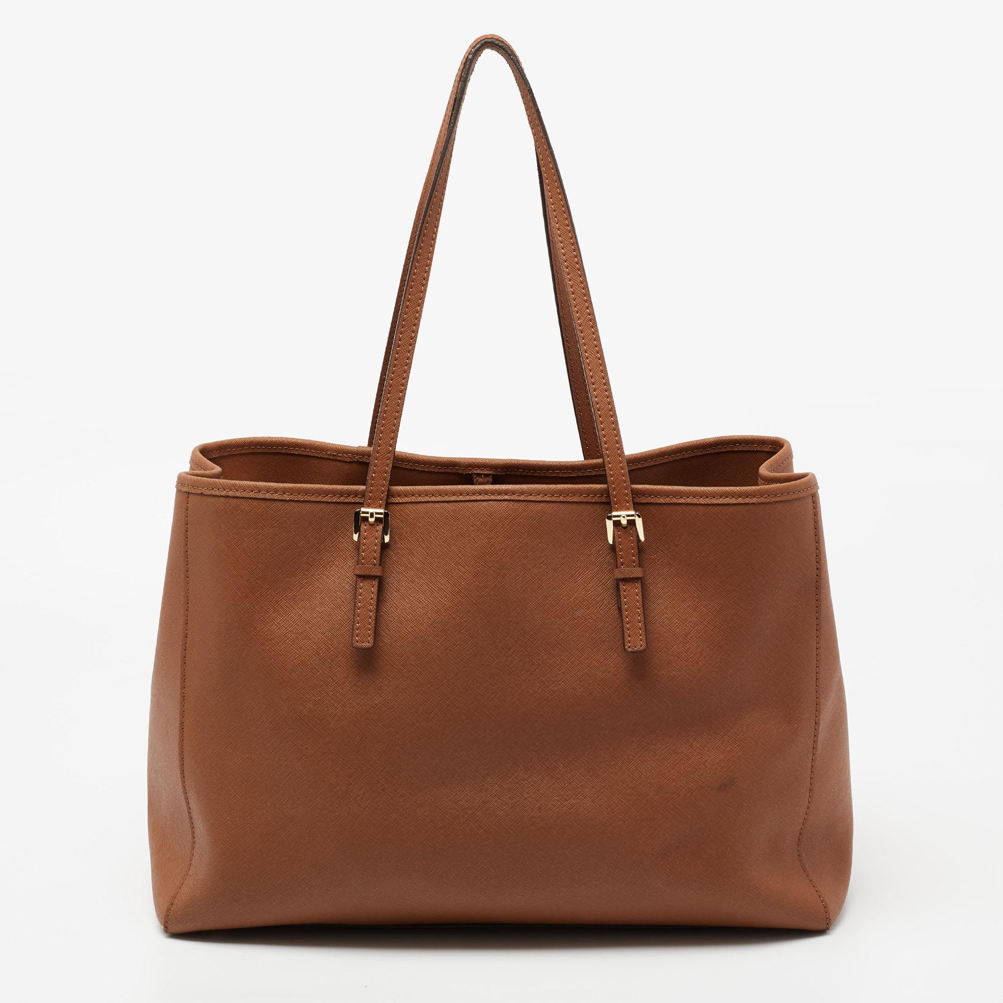 This Michael Kors Jet Set Travel tote aims to provide you with practical ease. With a beautiful design and striking structure, this Saffianoleather bag is filled with functional details. It exhibits dual handles at the top for you to carry it in a