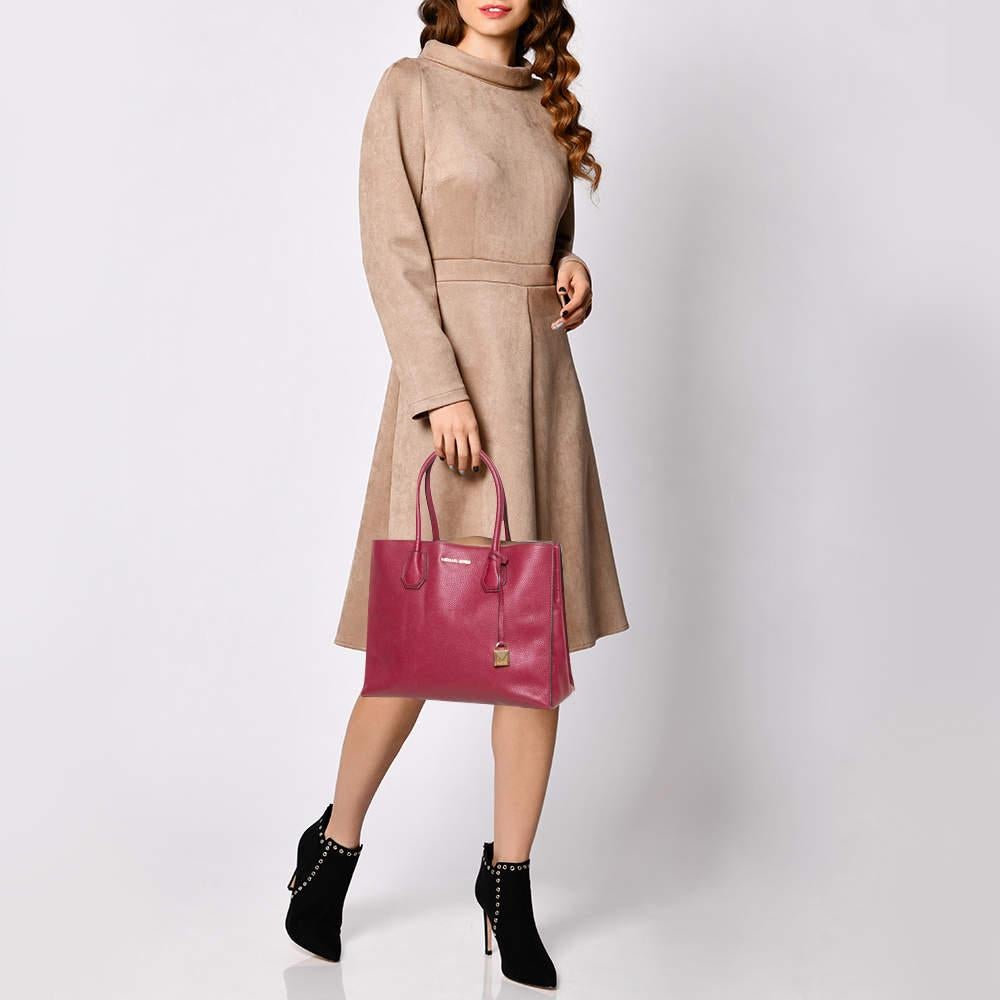 Caratterizzata da uno stile chic e favoloso, questa tote di Michael Kors è moderna. Realizzata in pelle martellata in un'incantevole tonalità di bordeaux, la tote è dotata di doppio manico, logo del marchio sul davanti e lucchetto penzolante. Si