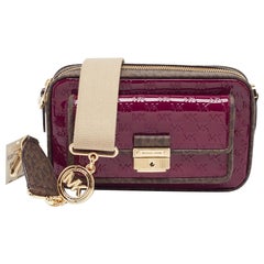 Michael Kors Bolso cruzado Bradshaw de charol y lona burdeos con firma