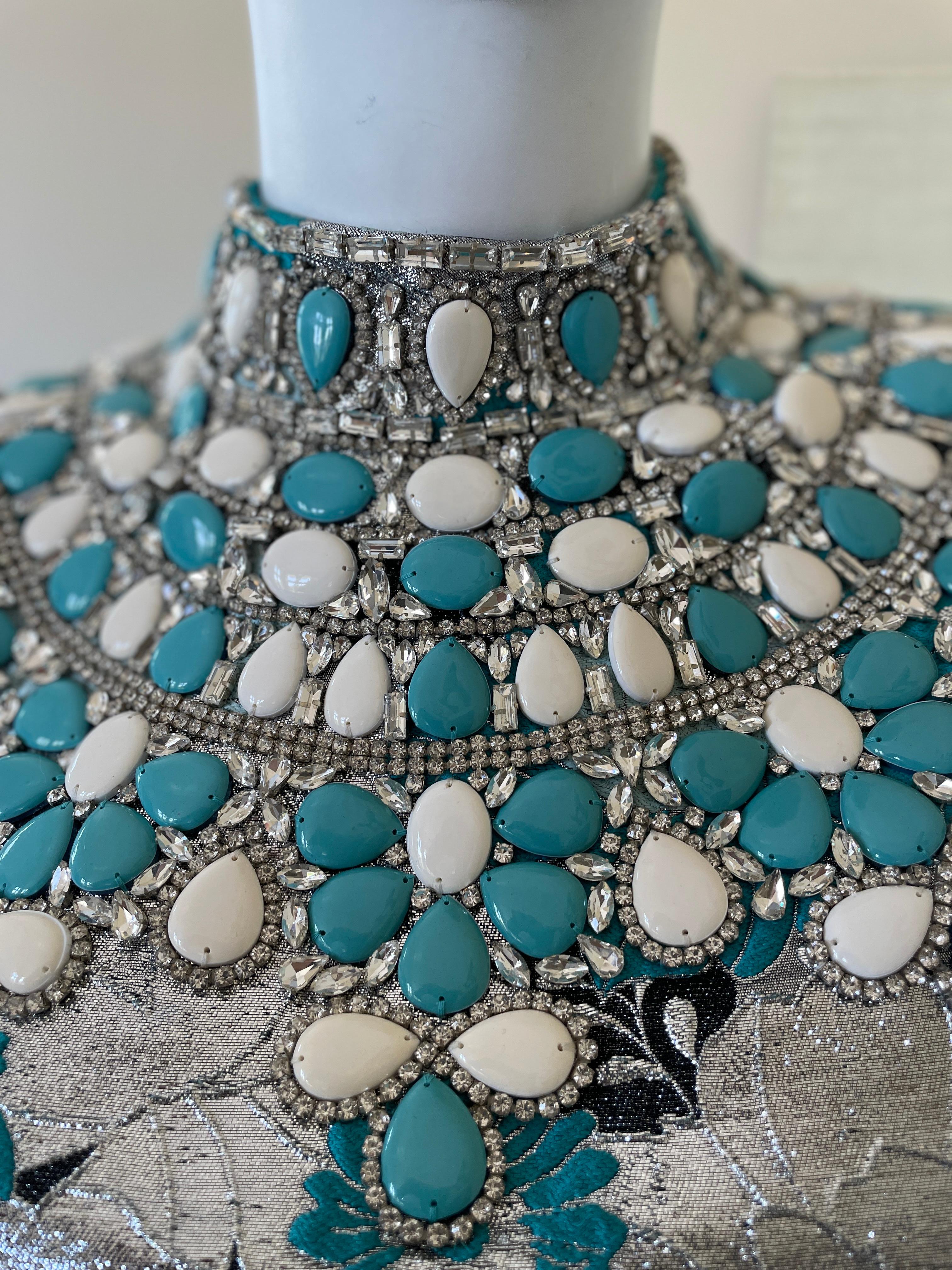 Michael Kors Collection Silver Brocade Dress with Gobsmacking Turquoise Crystal Collar.
Sixties style shift dress in mod floral silver brocade with an astonishing crystal and turquoise collar
Stunning. Please use the zoom feature to see all the