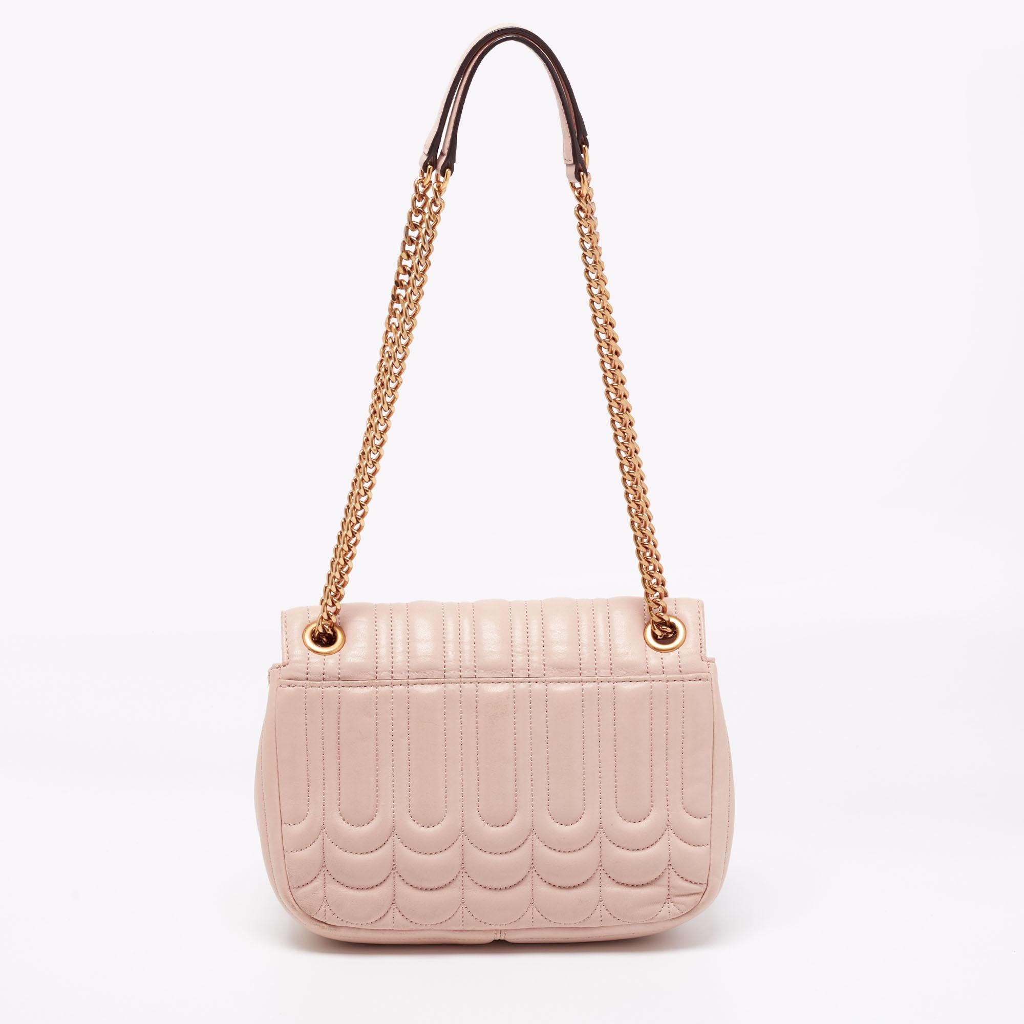 Anyone who loves handbags wants to own one from Michael Kors. This classic shoulder bag from their Vivianne collection is made from dusty pink, floral quilted leather. It has a gold-tone closure with the brand's name on it and chain handles with a