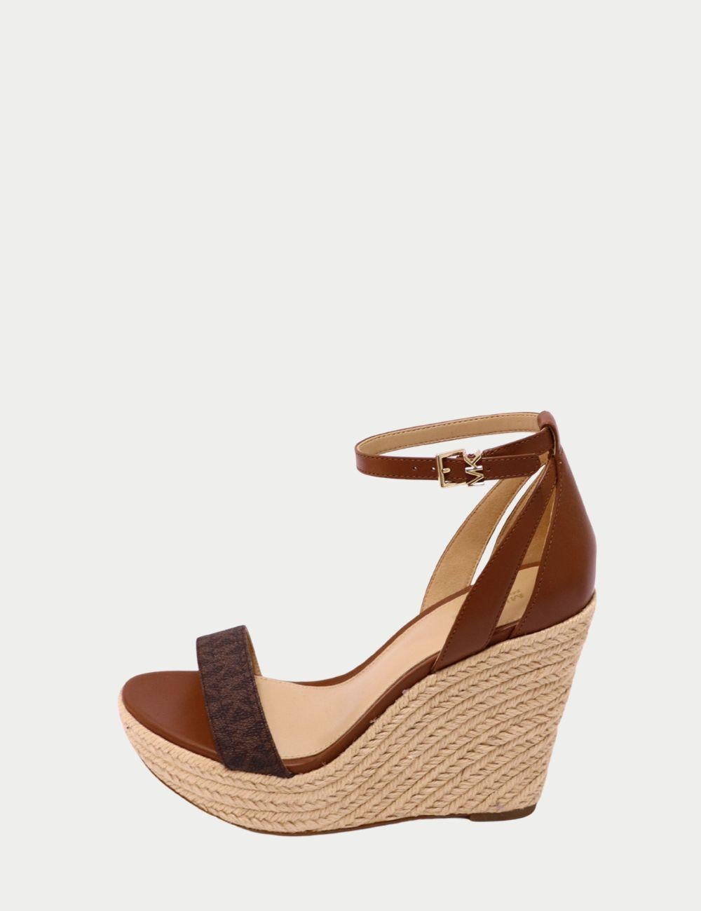 Michael Kors Sandalias con cuña de piel marrón y rafia con logotipo - Tacones con plataforma y tira al tobillo


Adéntrate en la sofisticación veraniega con estas sandalias de cuña de rafia de Michael Kors. Diseñadas con una mezcla de piel lisa