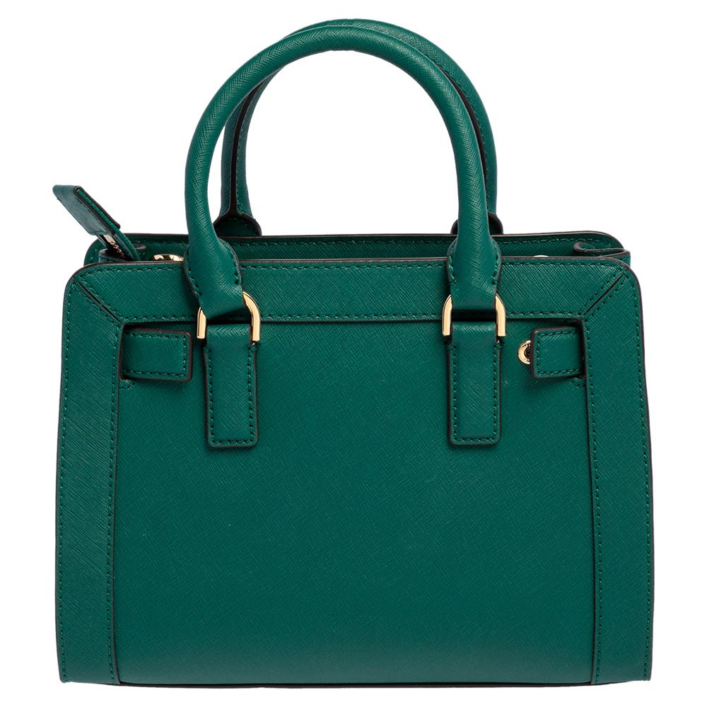 Deserving a very special place in your closet is this tote from Michael Kors! The green bag is crafted from leather and features dual top handles. It flaunts the brand logo on the front and opens to a spacious nylon-lined interior capable of holding