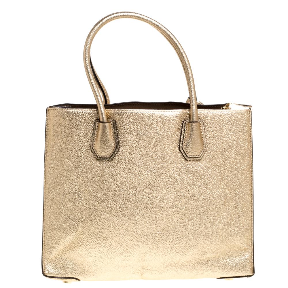 Diese Michael Kors-Tasche ist eine feine Kreation mit einem fabelhaften Stil. Die aus goldfarbenem Leder gefertigte Tasche verfügt über zwei Griffe und ein Vorhängeschloss. Sie öffnet sich zu einem geräumigen Innenraum aus Leder:: der durch ein