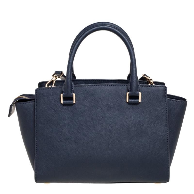 Mit der Selma Satchel von MICHAEL Michael Kors bringen Sie Ihren Stil auf ein ganz neues Niveau. Sie ist aus marineblauem Leder gefertigt und verfügt über zwei gerollte Griffe an der Oberseite. Sie öffnet sich zu einem geräumigen, nylongefütterten