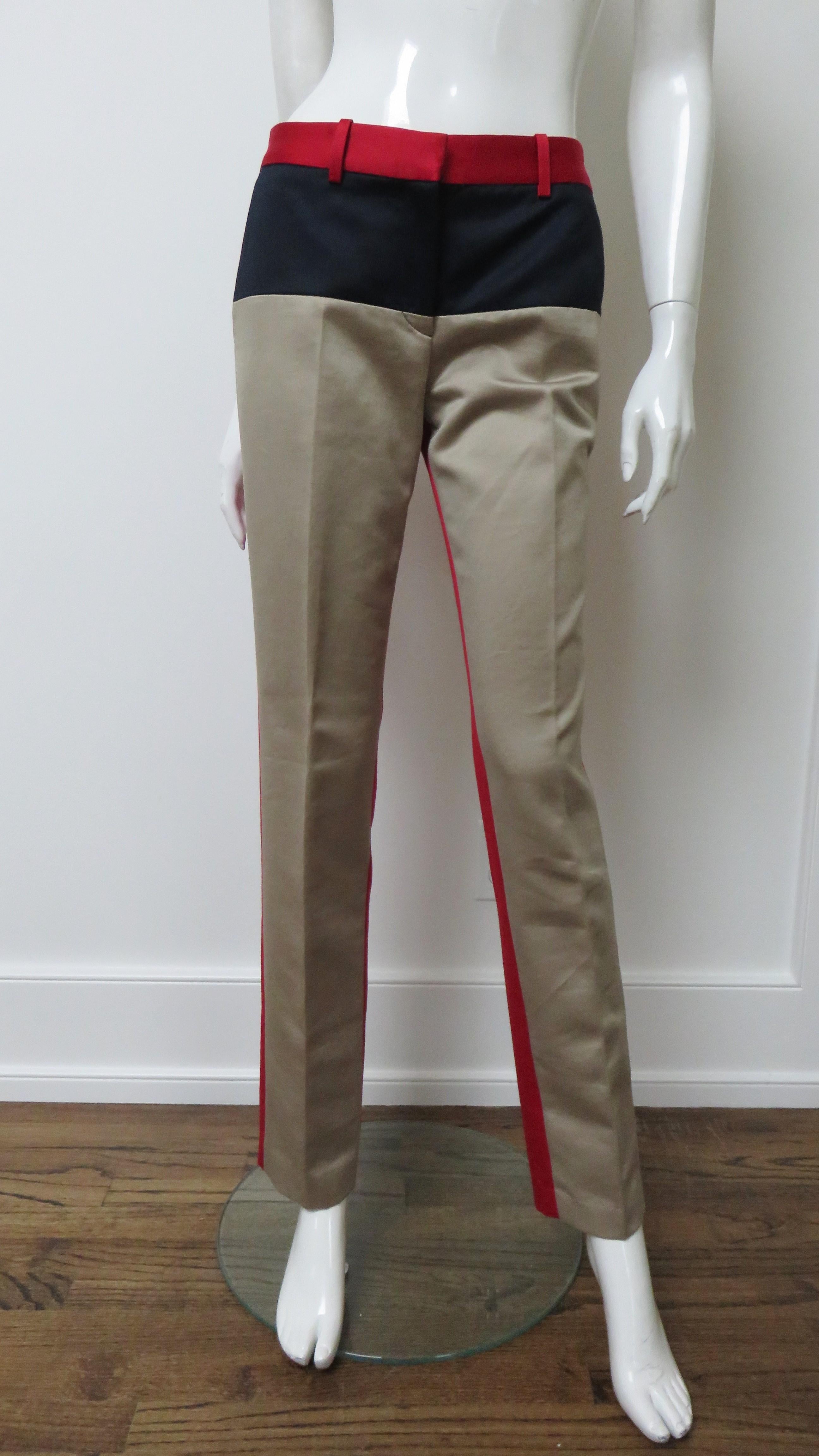 Fabulous red, black and camel taupe polished cotton pants by Michael Kors. They are mid rise with a red waistband, a black panel across the front hips, and taupe front straight legs. The entire back of the pants are solid red. They have front hip
