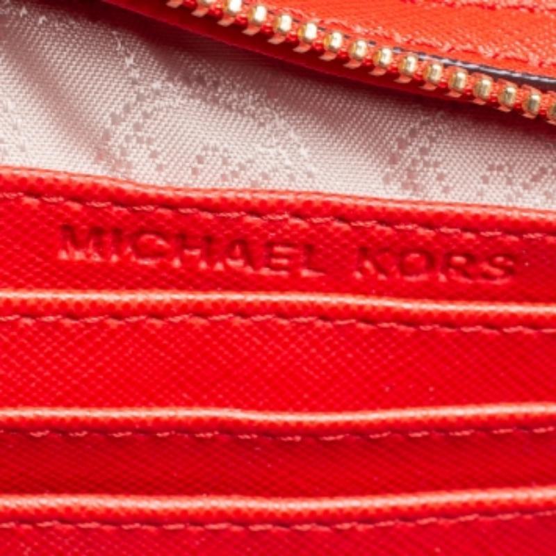 This adorable Selma crossbody bag from Michael Kors is both elegant and fashionable. Crafted from orange Saffiano leather, the bag features an adjustable shoulder strap. The fabric-lined interior houses a slip pocket along with a zip pocket and will