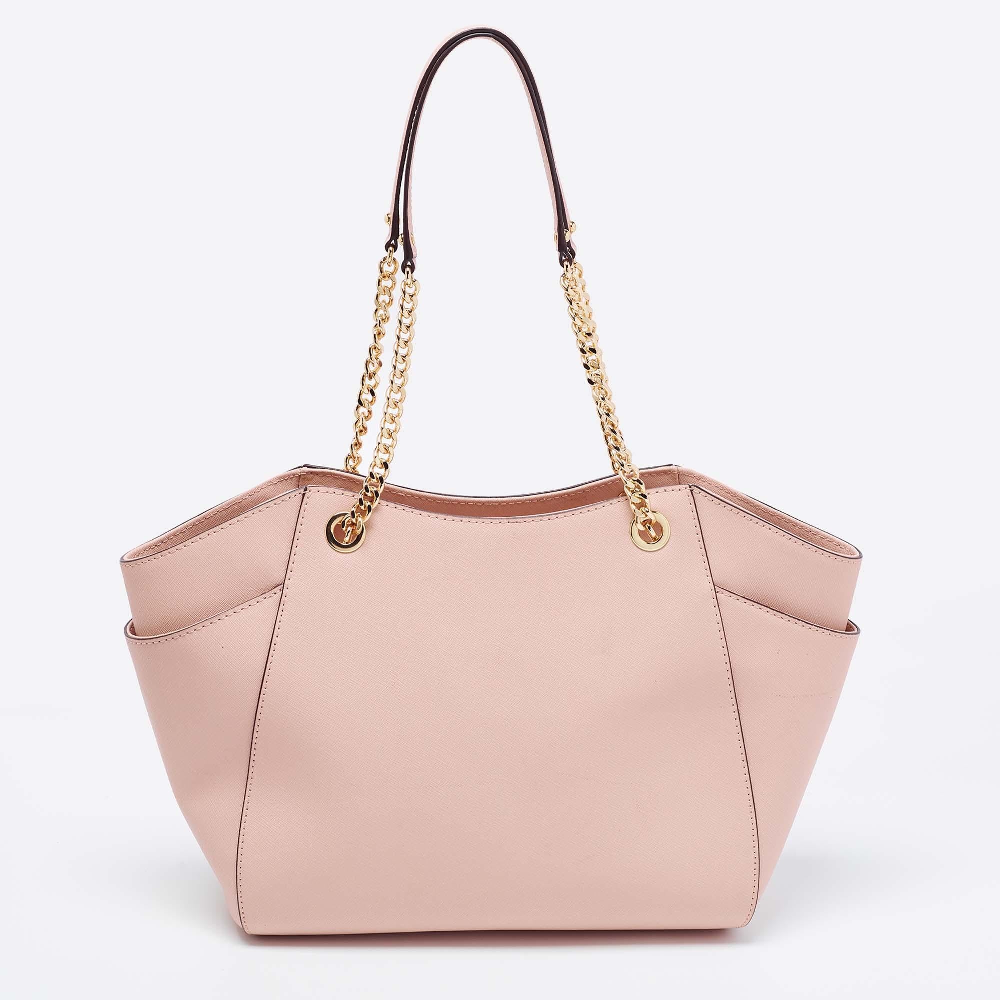 This Michael Kors Jet Set Travel tote aims to provide you with practical ease. With a beautiful design and striking structure, this leather bag is filled with luxurious details. It exhibits dual chain-leather handles for you to carry it in a chic