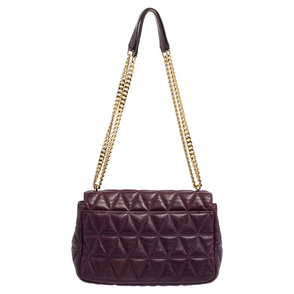 This stylish leather handbag marks pure style with its alluring features. The simple and durable fabric lining, gold-tone hardware, and quilted leather exterior make for the ideal accessory. Carry this Michael Kors purple handbag to your next event