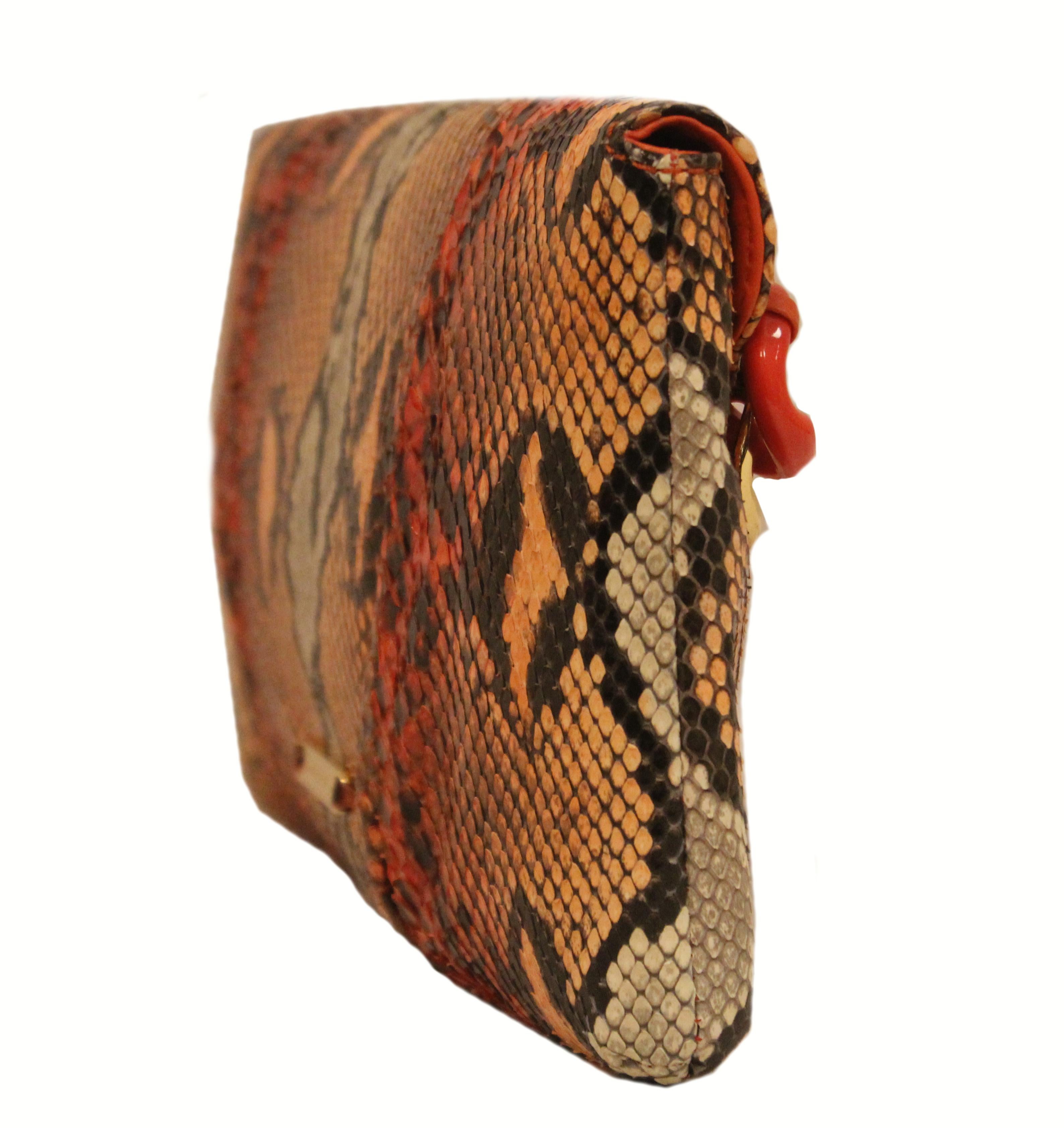 Michael Kors Python peach and brown clutch incorporates a thick gold tone and orange chain link accent at front.   The flap is lined in bright orange leather and the interior is lined in peach color suede and it includes one side slit pocket.   For
