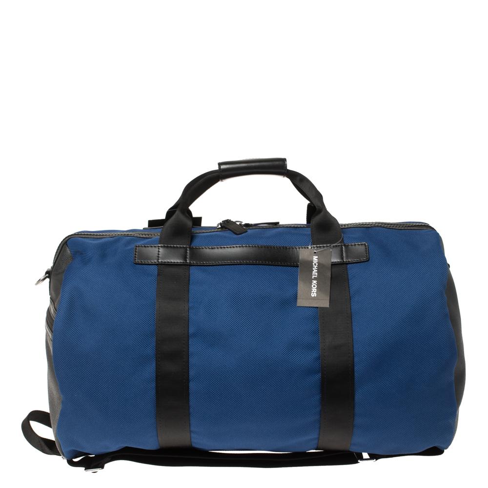 A functional duffel bag with a unique convertible design, this bag by Michael Kors is a winner. Crafted from blue nylon and black leather, it has handles and a shoulder strap. The nylon-lined interior has pockets to store your little essentials.