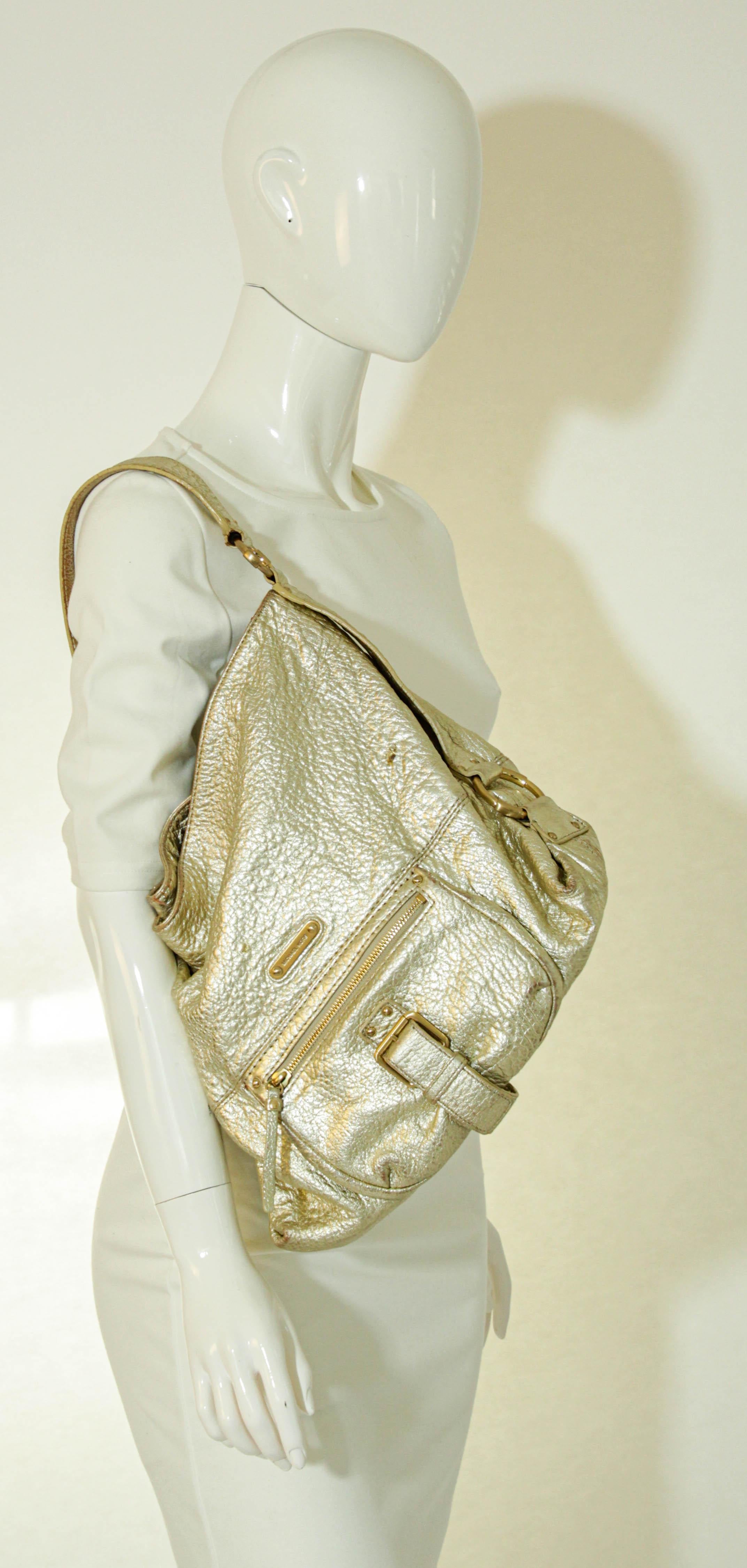 Michael Kors Satchel White Gold Pebbled Leather Hobo Bag.
Gold Pebbled leather Michael Kors satchel fashioned from supple, lightly textured white gold metallic leather and gold hardware. 
Buckle tap accents front zip pocket to subtly mirror cinched