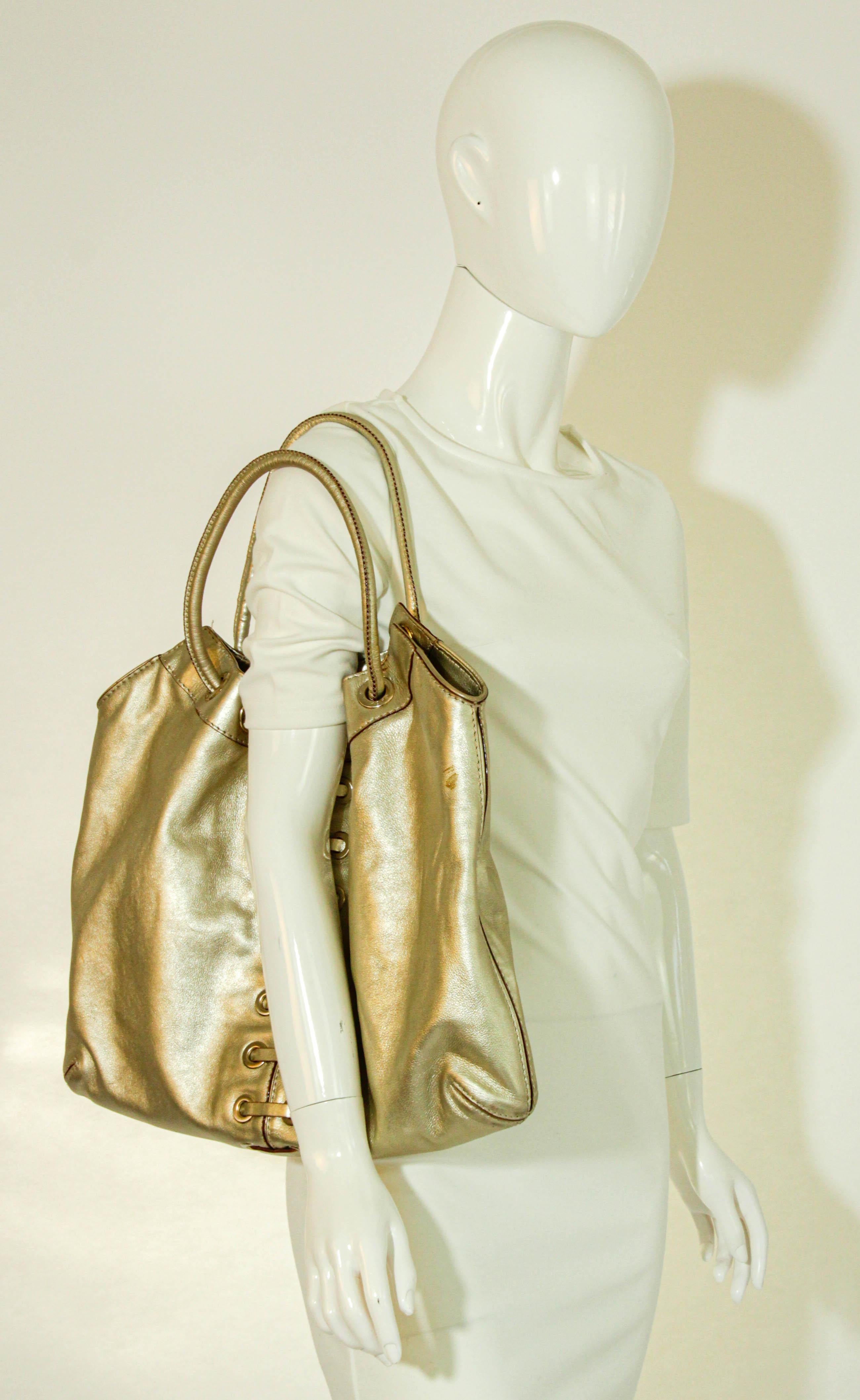 Michael Kors Satchel White Gold Pebbled Leather Hobo Bag.
Gold Pebbled leather Michael Kors satchel fashioned from supple, lightly textured white gold metallic leather and gold hardware. 
Buckle tap accents front zip pocket to subtly mirror cinched