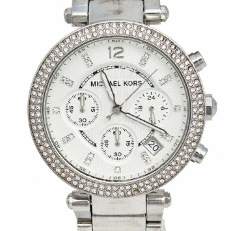 Este reloj Michael Kors brillará en tu muñeca. Está maravillosamente fabricado en acero inoxidable y diseñado con dos filas de cristales en el bisel. El cristal protege una esfera plateada que tiene elegantes índices horarios, tres subesferas, una