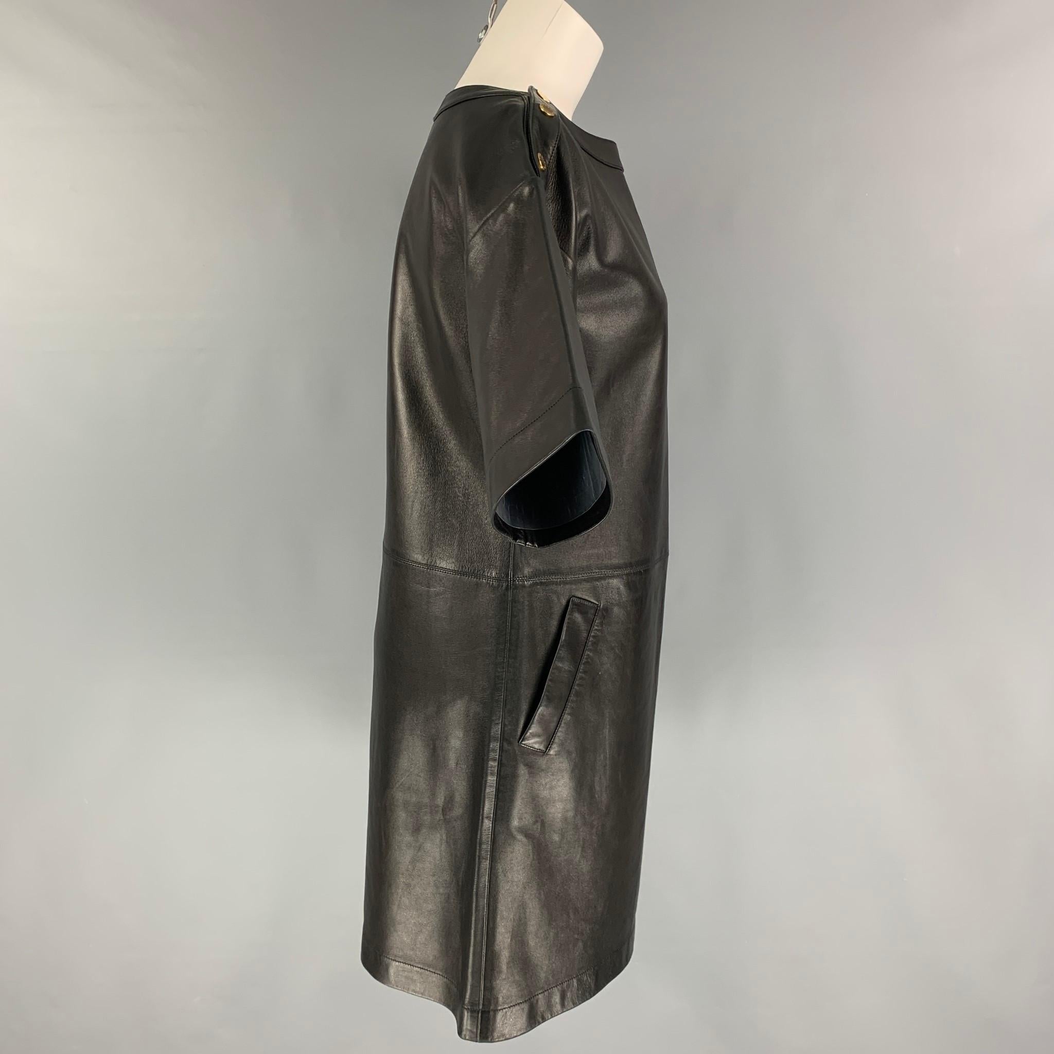 MICHAEL KORS dress comes in a black leather featuring short sleeves, slit pockets, and gold tone shoulder snap buttons. Made in Italy. 

Very Good Pre-Owned Condition.
Marked: 4

Measurements:

Shoulder: 21 in.
Bust: 38 in.
Waist: 36 in.
Hip: 39