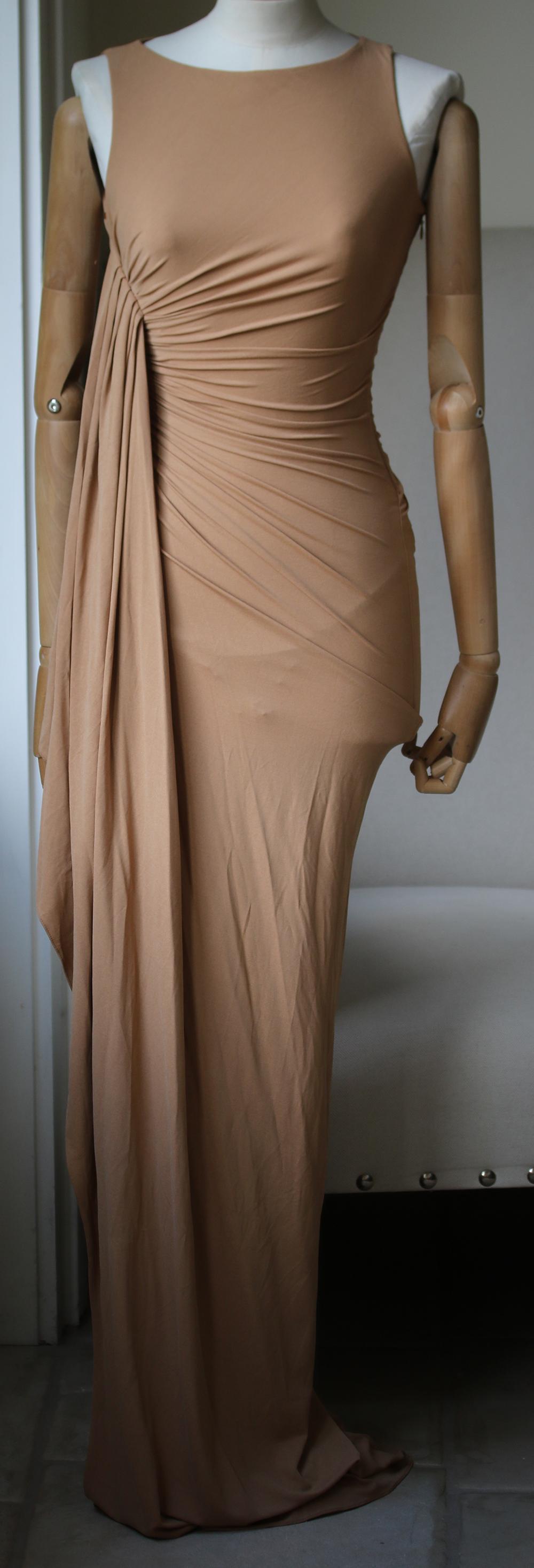 A red carpet favourite with the Hollywood set, Michael Kors' nude column gown is a scene-stealing style. A cascading drape and cross-body ruching will shape a stunning silhouette that needs little embellishment. Michael Kors sleeveless gown: nude