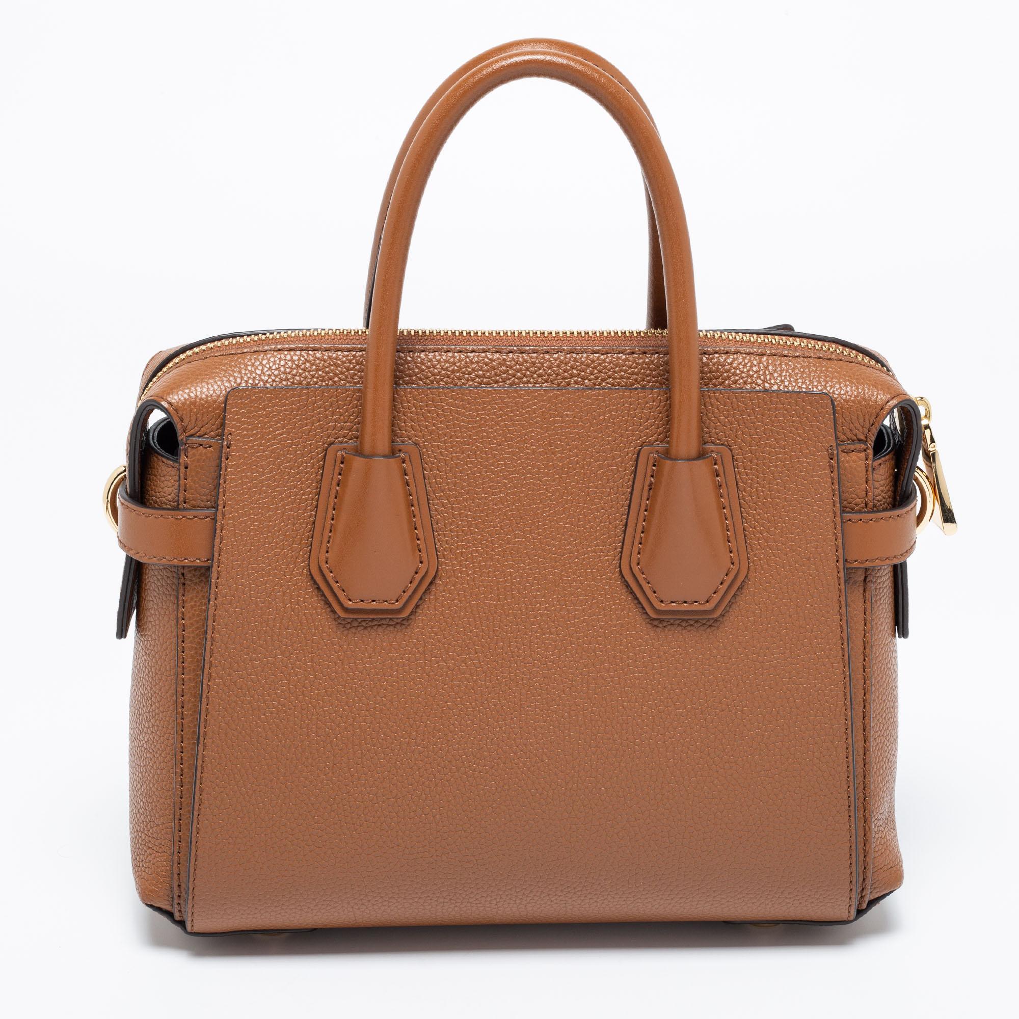 Featuring a chic and fabulous style, this Michael Kors tote is modern. Crafted from leather in a stunning tan hue, the bag features dual handles, a removable shoulder strap, and a padlock. It opens to a spacious interior having a zip pocket. It