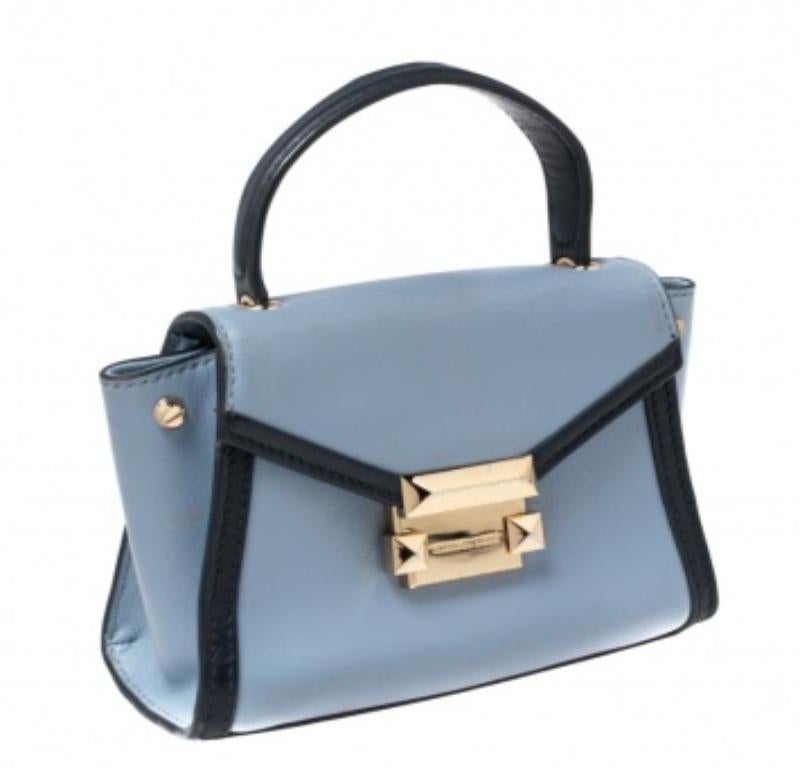 Le sac Whitney de Michael Kors est une véritable fusion de brillance et de style intemporel. Il est réalisé en cuir bleu bicolore, avec un logo gravé sur le devant. Il est orné de ferrures dorées, d'un intérieur doublé de tissu et d'une poignée