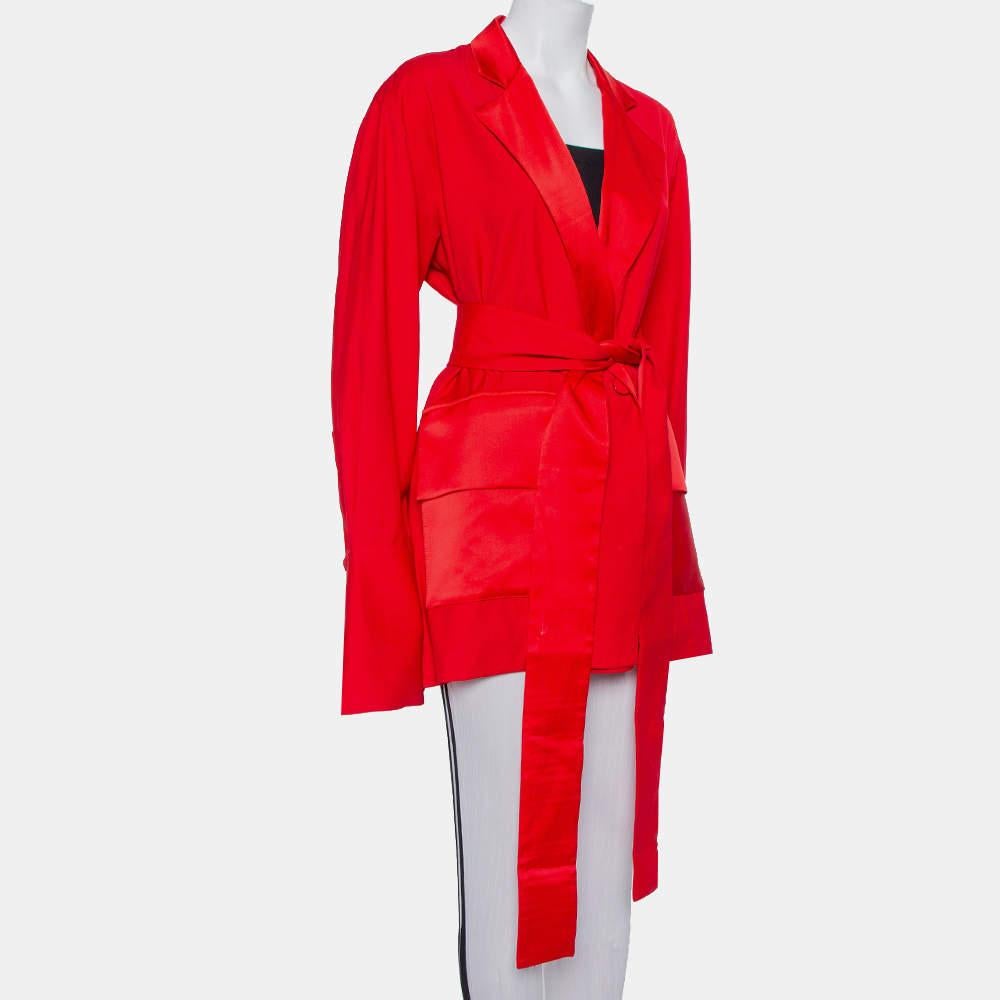 With this elegant blazer, Michael Lo Sordo introduces us to beautiful clothing that makes one feel and look good. Created using wool, the red blazer is detailed with satin lapels, pockets, and extra-long sleeves with split cuffs. It is secured with