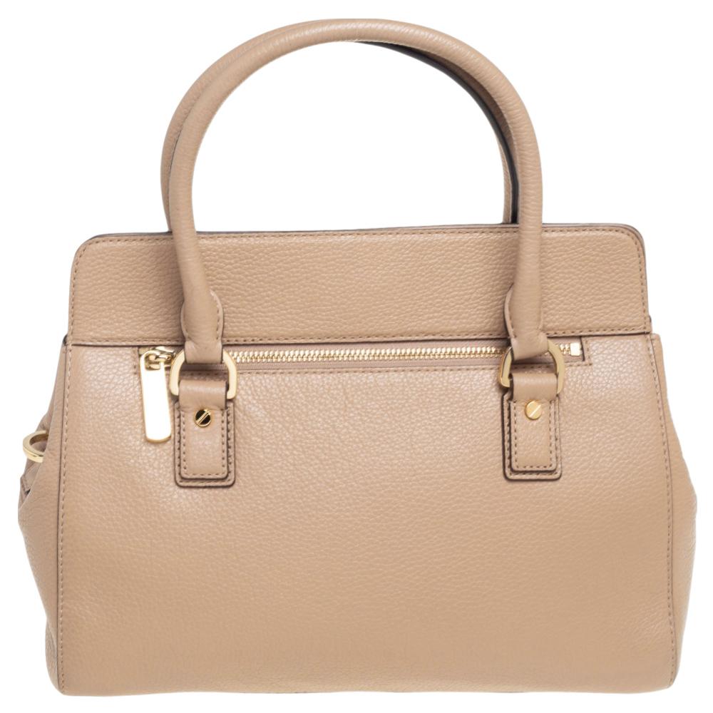 This MICHAEL Michael Kors satchel in a wonderful shade of beige is made just for the handbag lover in you. Crafted from leather, it is enhanced with gold-tone hardware and a MK charm. It is equipped with two short handles and a nylon-lined interior
