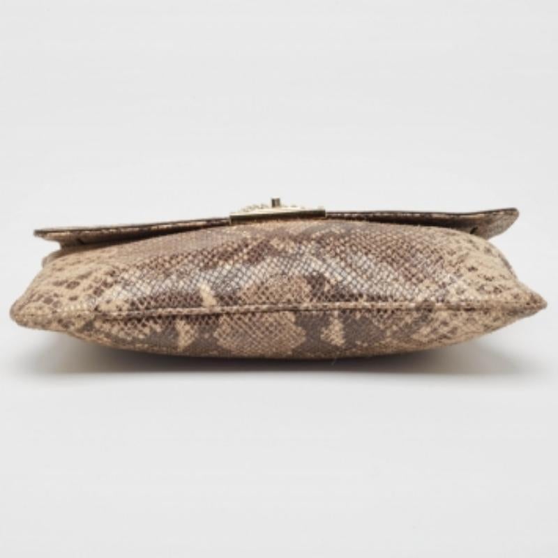 Adorna questa splendida borsa di Michael Kors. Realizzata in pelle di pitone goffrata, la borsa è dotata di una catena dorata. La chiusura a girello si apre su un interno foderato in tessuto che ospita una tasca con zip e tasche portaoggetti.
