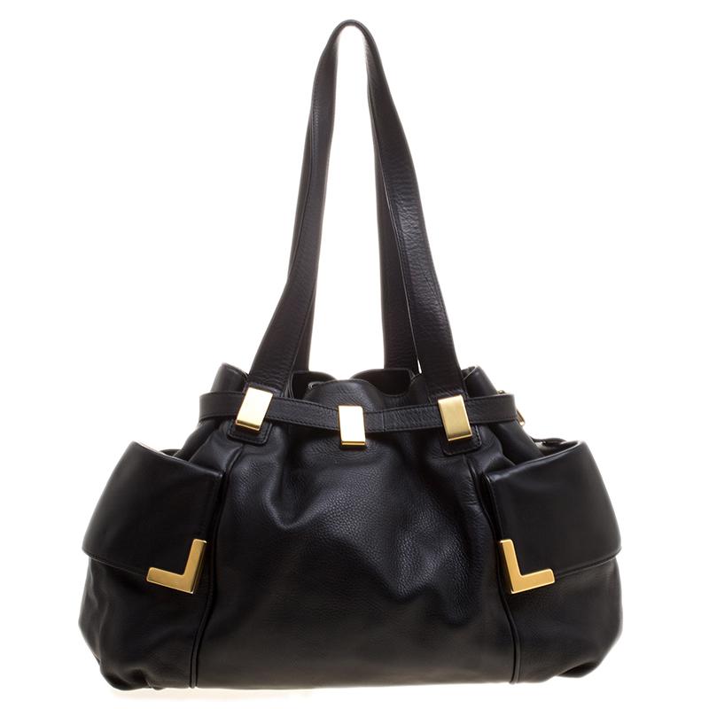 This Michael Kors tote has an edgy silhouette and is styled with a drawstring closure. The lovely satin lined interior houses two slip pockets and a zip pocket. Very much in vogue, look stylish while carrying this tote.

Includes: The Luxury Closet