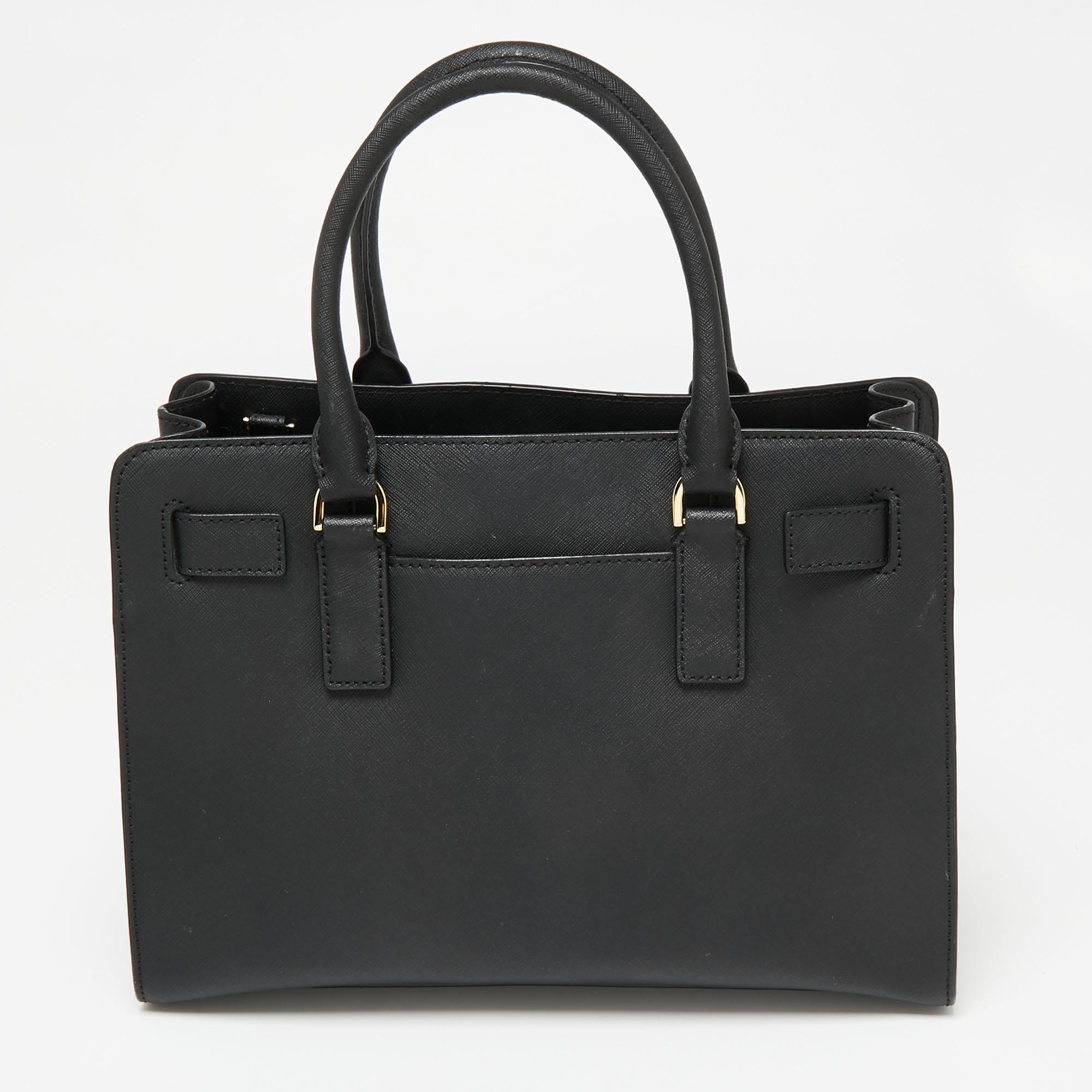 Diese Dillon-Tasche von MICHAEL Michael Kors ist ideal für den täglichen Gebrauch. Sie ist aus schwarzem Saffiano-Leder gefertigt und verfügt über zwei Griffe, goldfarbene Beschläge und ein nylongefüttertes Innenleben. Diese Tasche lässt Sie