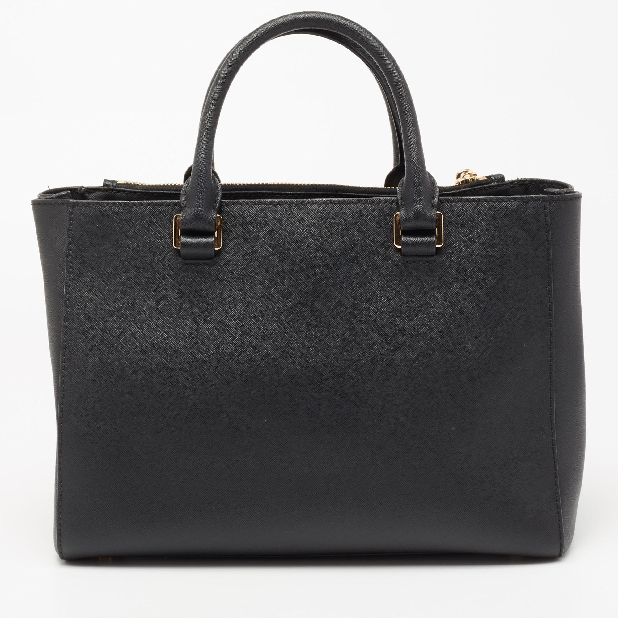 This admirable tote from MICHAEL Michael Kors is a true beauty. Crafted from black Saffiano leather, it is designed to complement your sophisticated personality. The interior of this bag is enduring and capacious. The tote comes with dual handles,