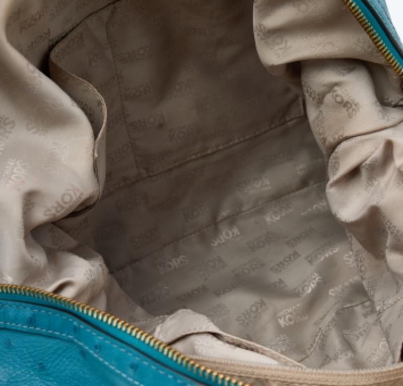 Questa elegante tote di Michael Kors è un acquisto che vale la pena fare. È stata realizzata in pelle goffrata a struzzo in una tonalità blu e decorata con un charm con logo sul davanti. La borsa ha due manici, una tracolla e uno spazioso interno in