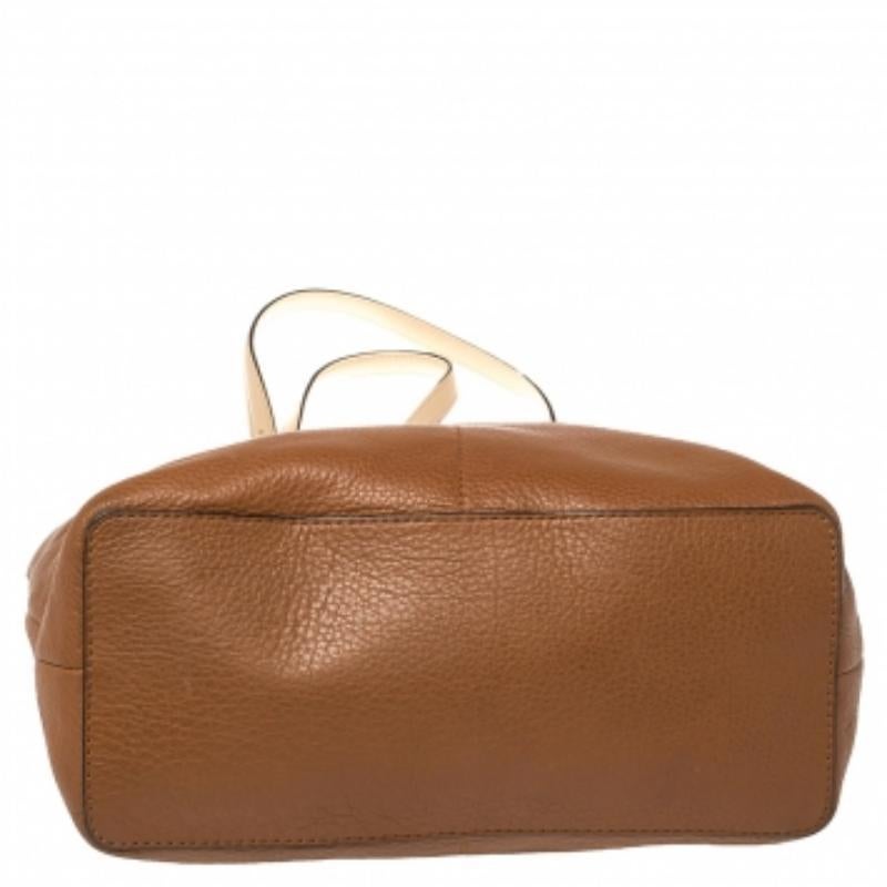 Pair this MICHAEL Michael Kors Bedford tote with any outfit and look fashionable. The bag is crafted from leather and features dual handles with buckle details and the brand logo on the front. The spacious nylon-lined interior will dutifully hold