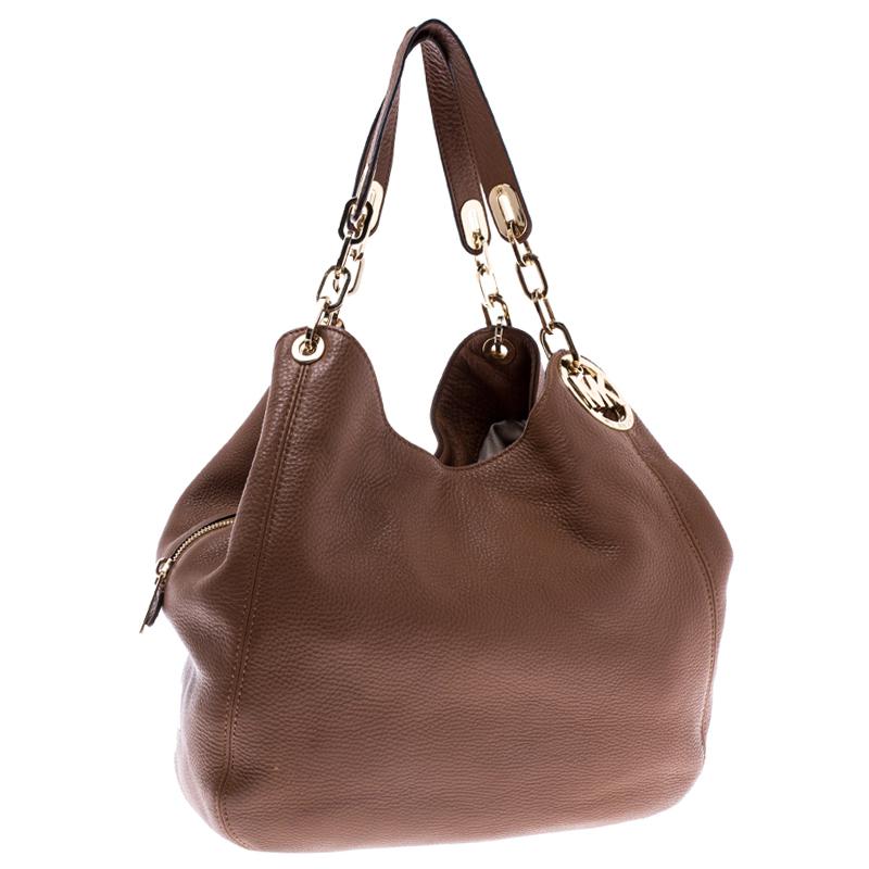 Grand and posh, style your outfit with this brown Fulton bag from Michael Michael Kors. Crafted from leather it features dual handles. The nylon lined interior houses a zip and two slip pockets.

Includes: The Luxury Closet Packaging

